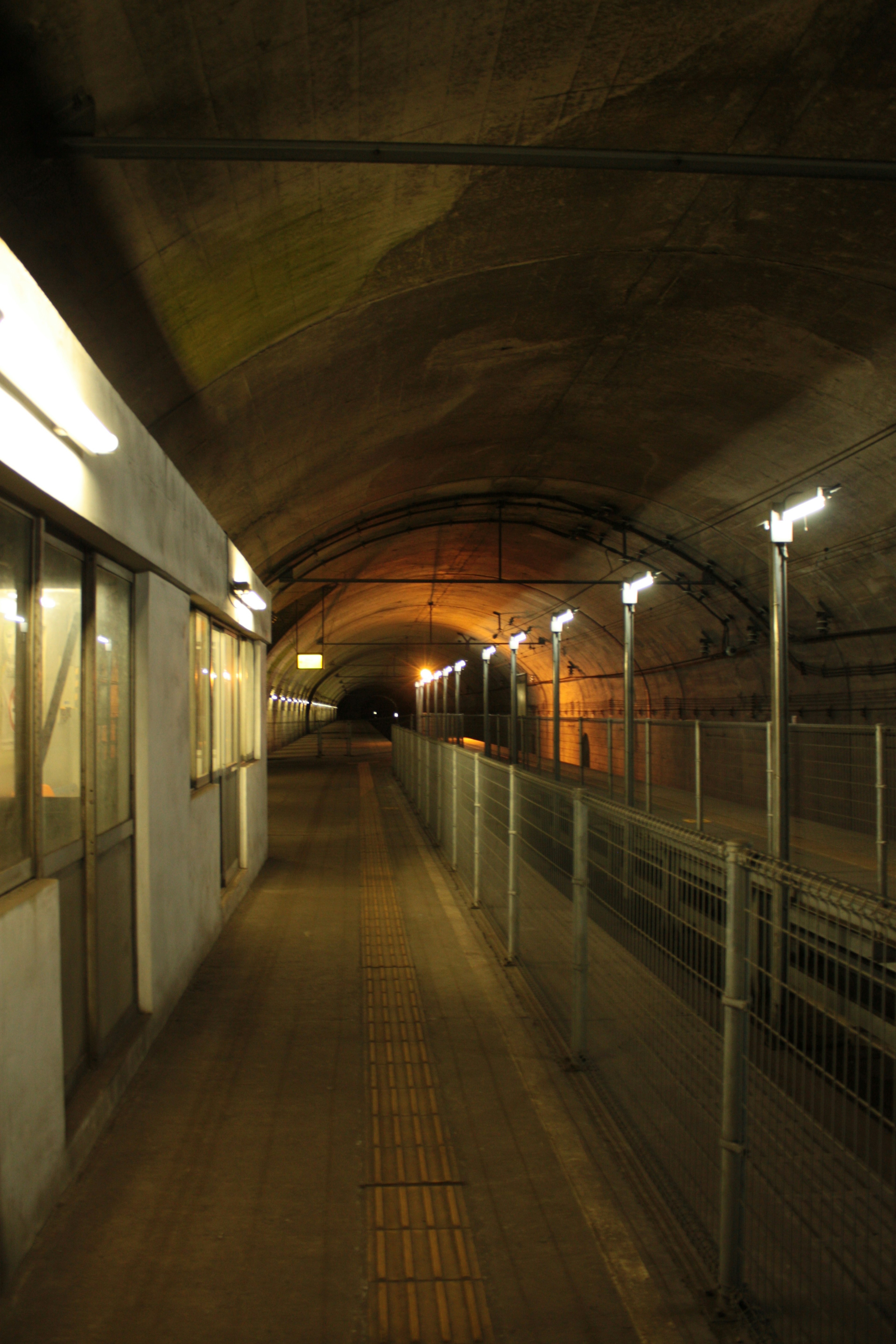 Intérieur de tunnel faiblement éclairé avec un chemin et des barrières