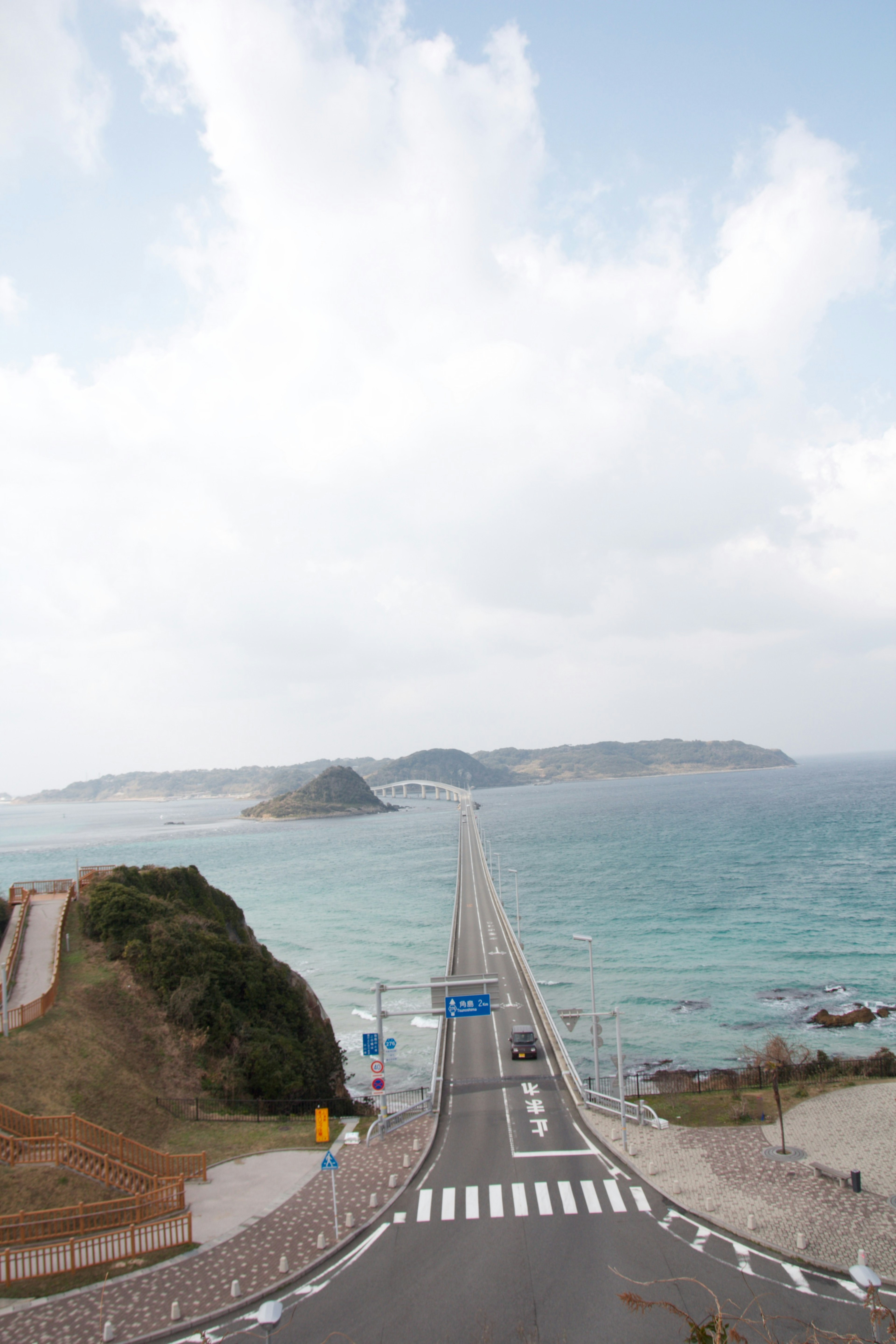 Scenic view of a road leading to an island over the ocean