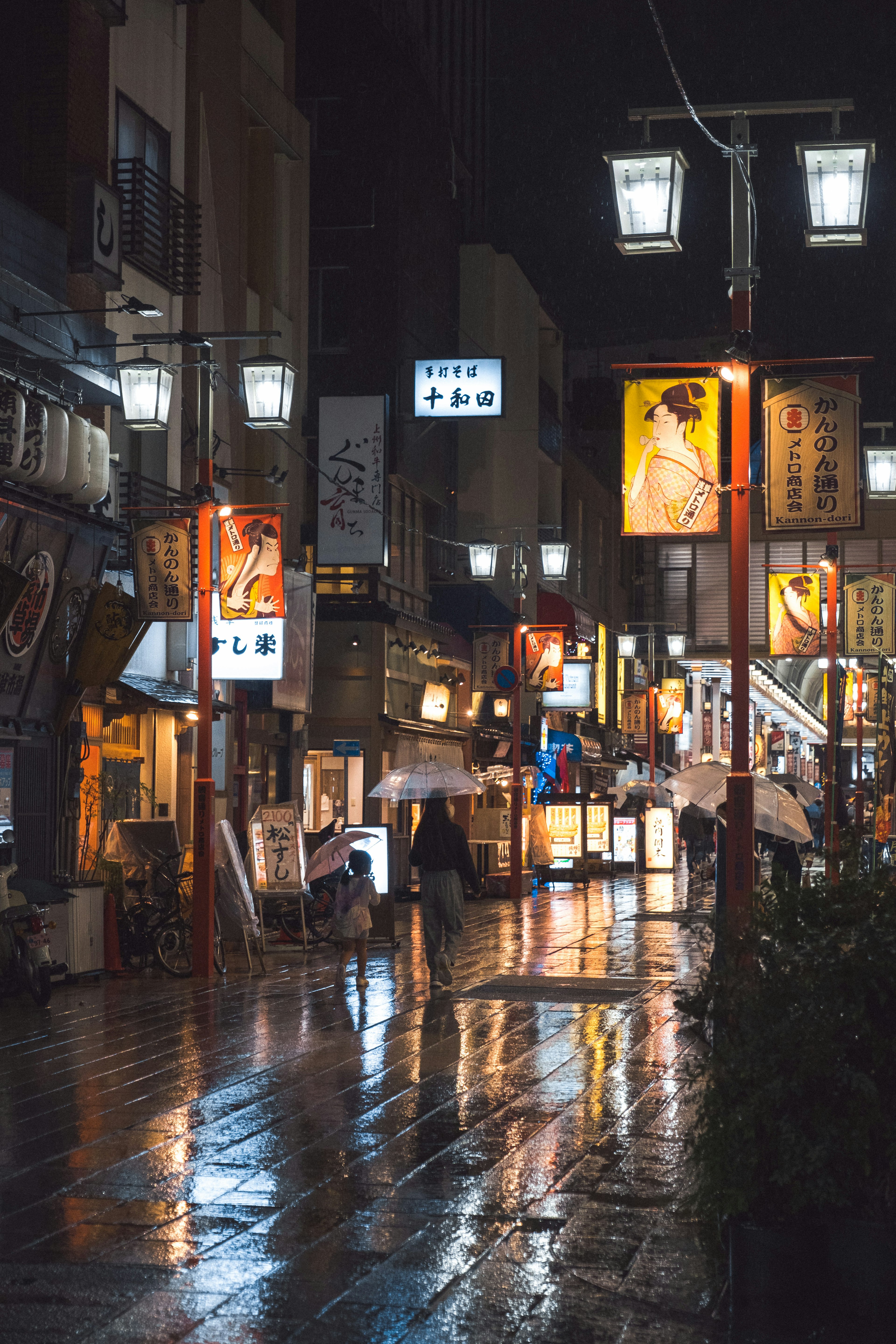 夜の街並みの反射と提灯のある通り