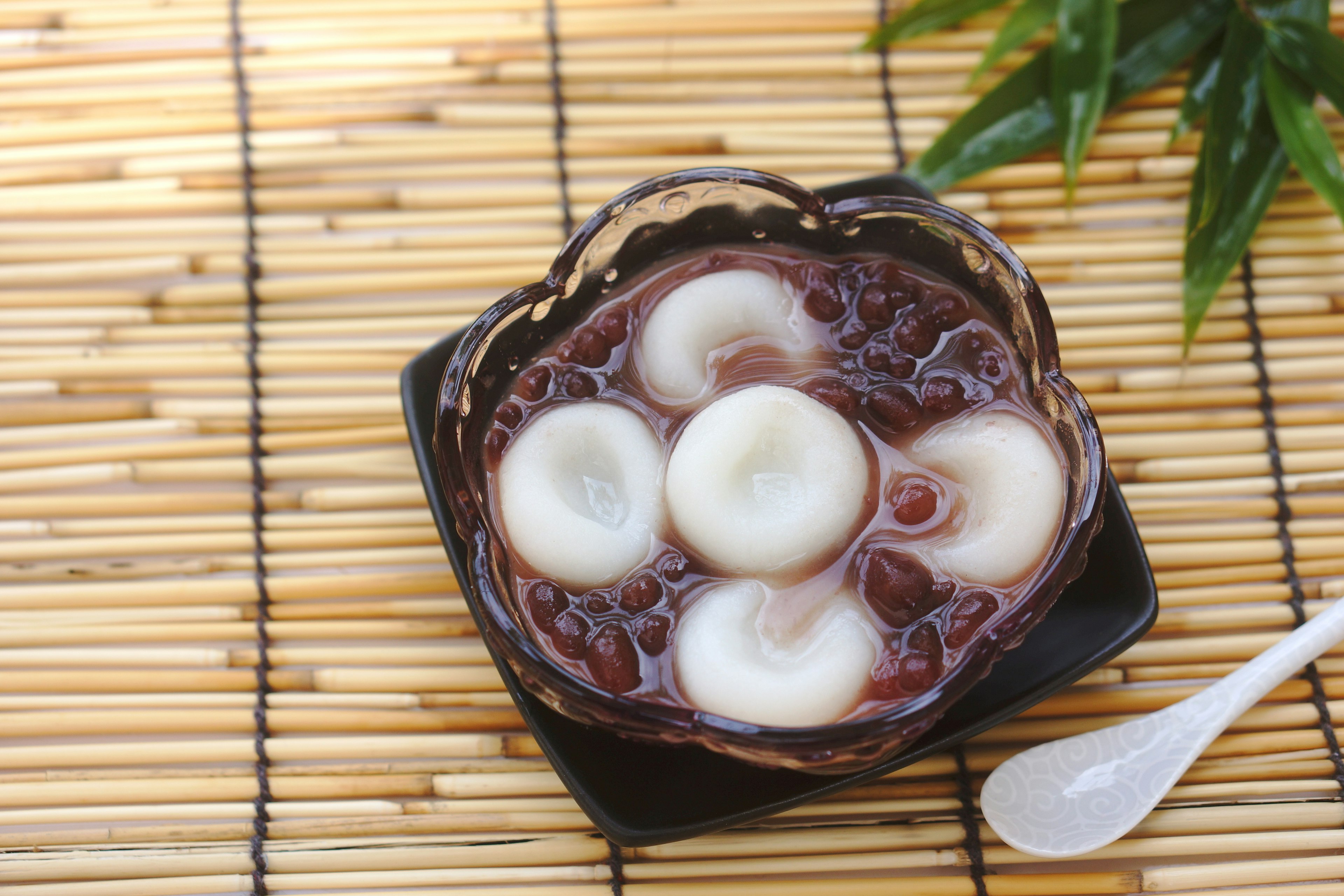 Dessert with red bean and glutinous rice balls served in a black bowl