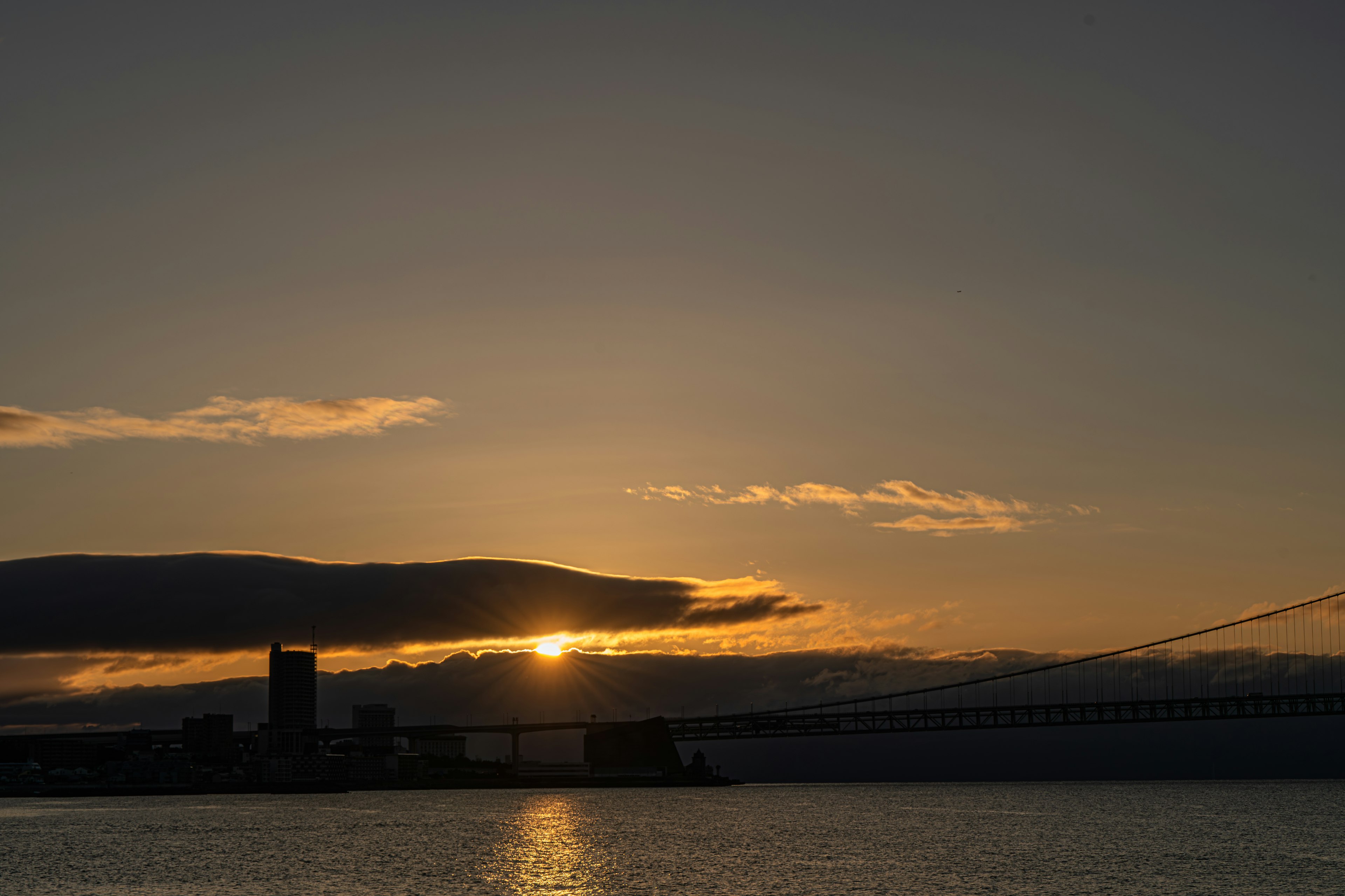 夕日が沈む海の景色とシルエットの建物