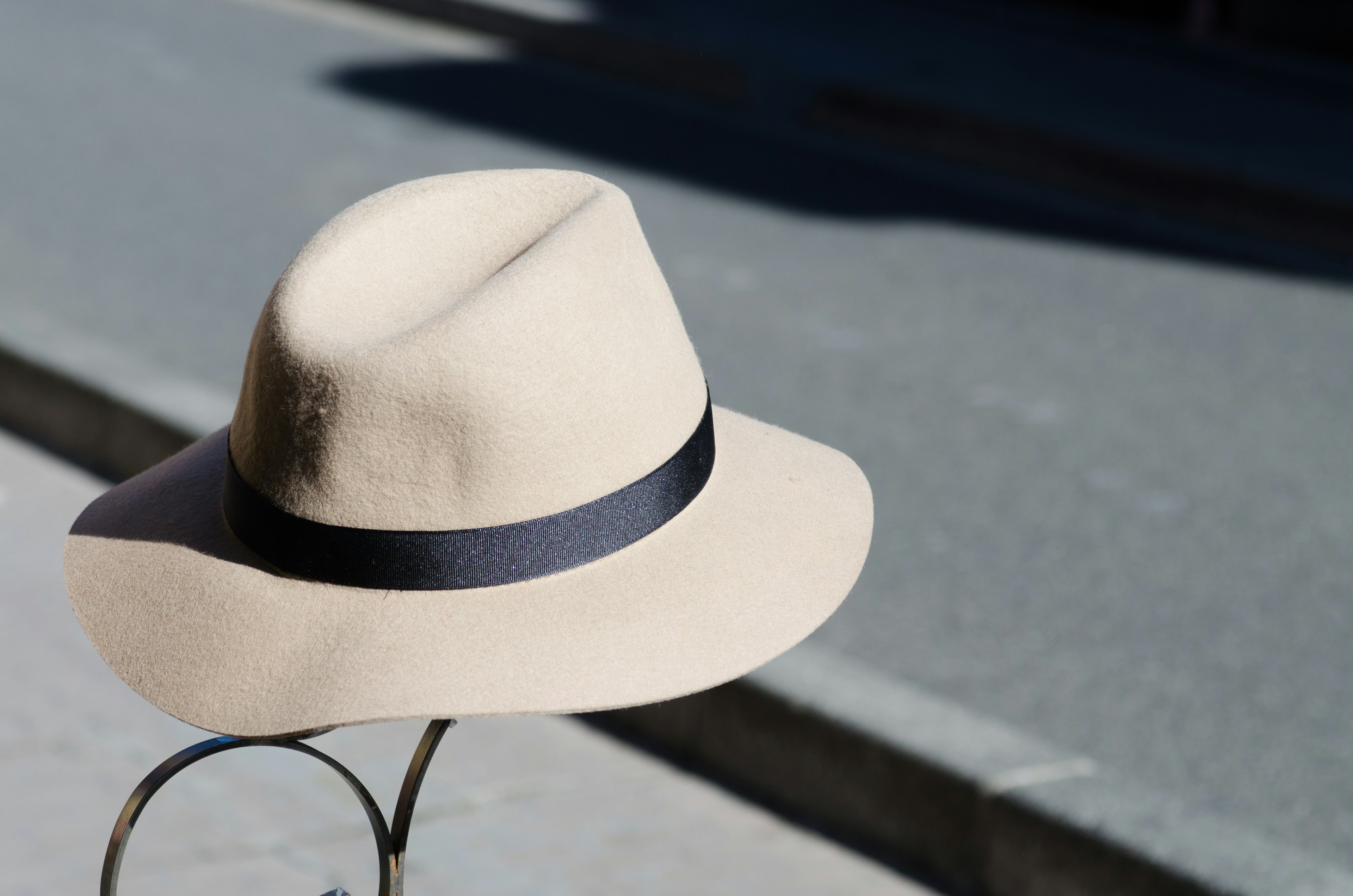 Topi beige dengan pita hitam di bawah sinar matahari