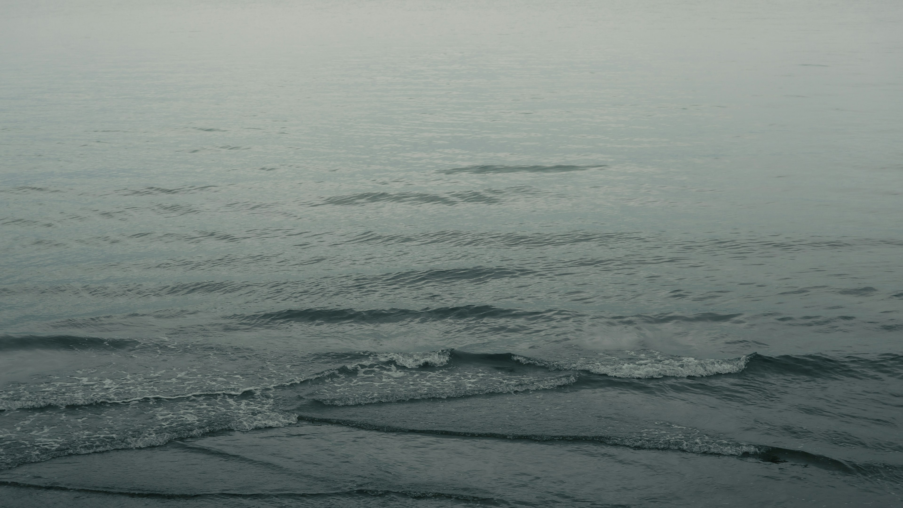 Calm sea view with gentle waves and a misty sky