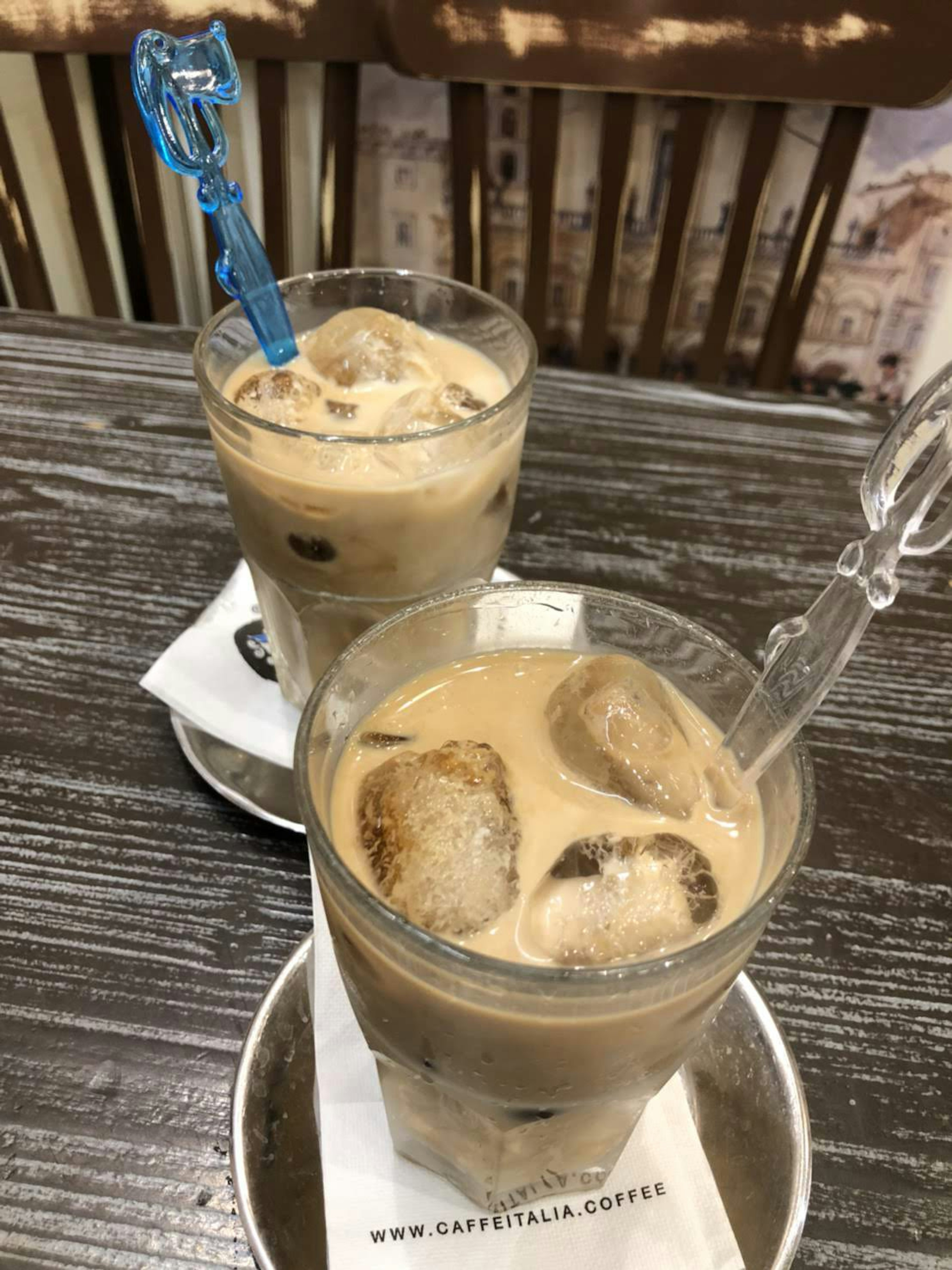 Deux verres de café glacé avec des glaçons et une cuillère bleue