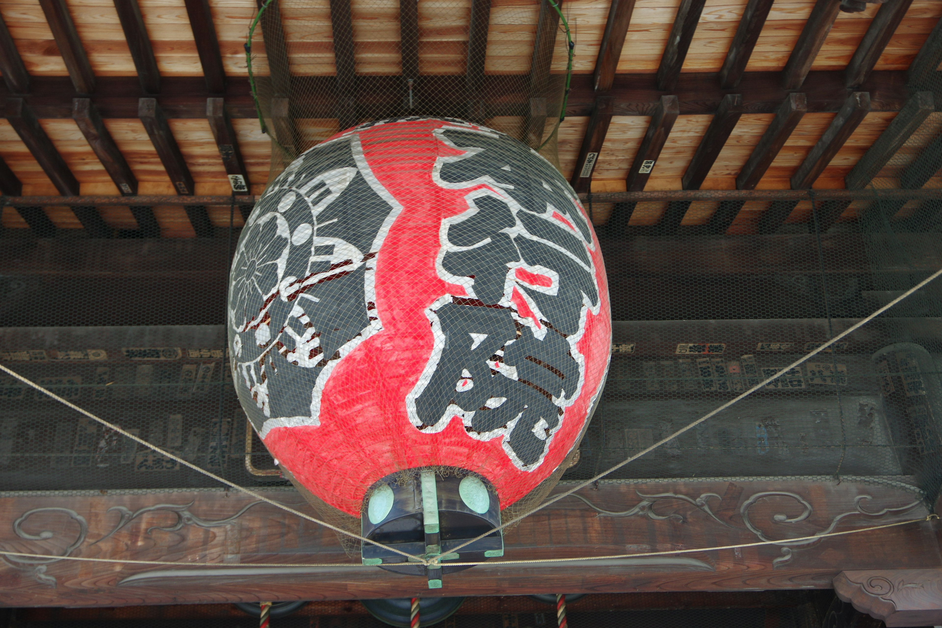 Large red lantern featuring black calligraphy traditional Japanese decoration