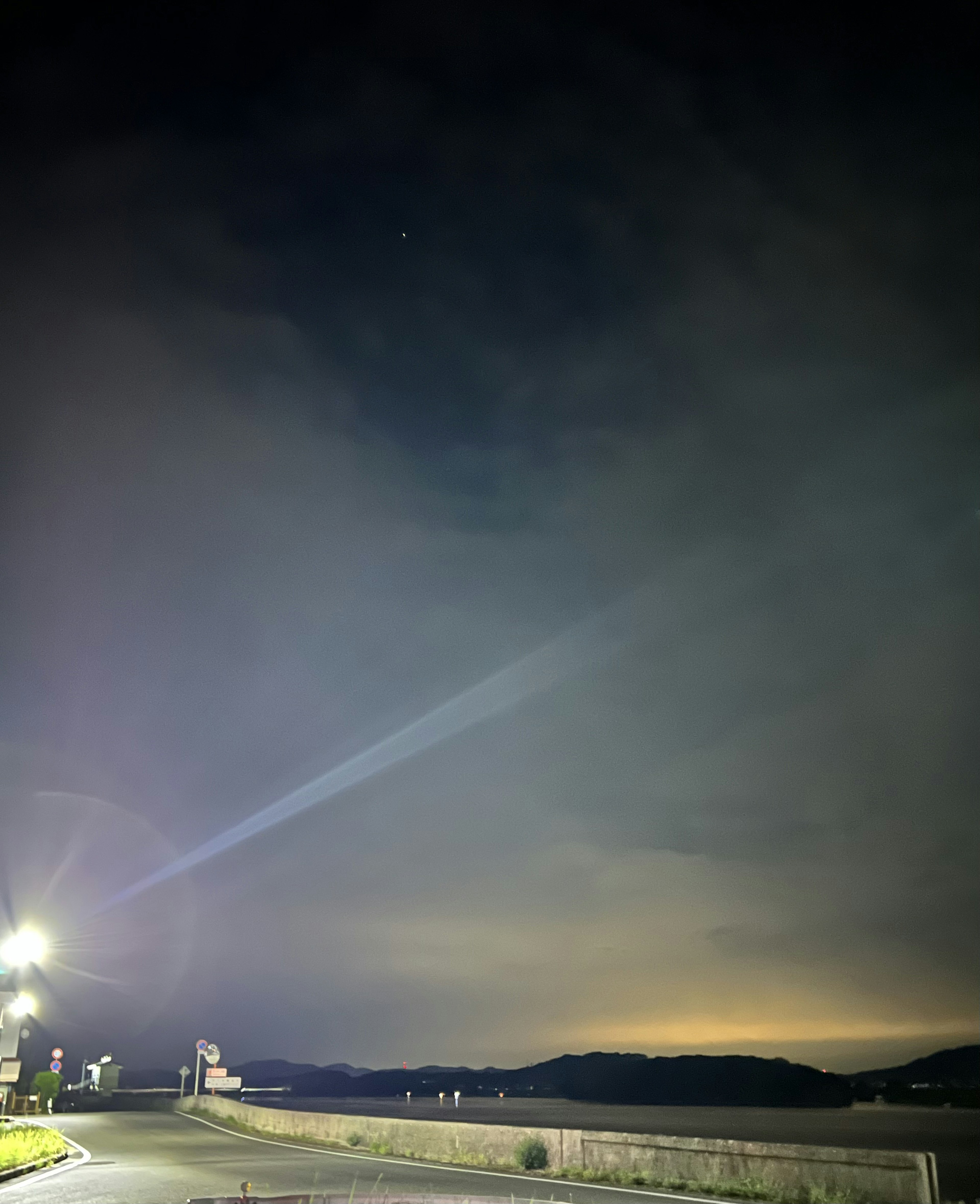 Impressionante scena notturna con nuvole e un fascio di luce nel cielo