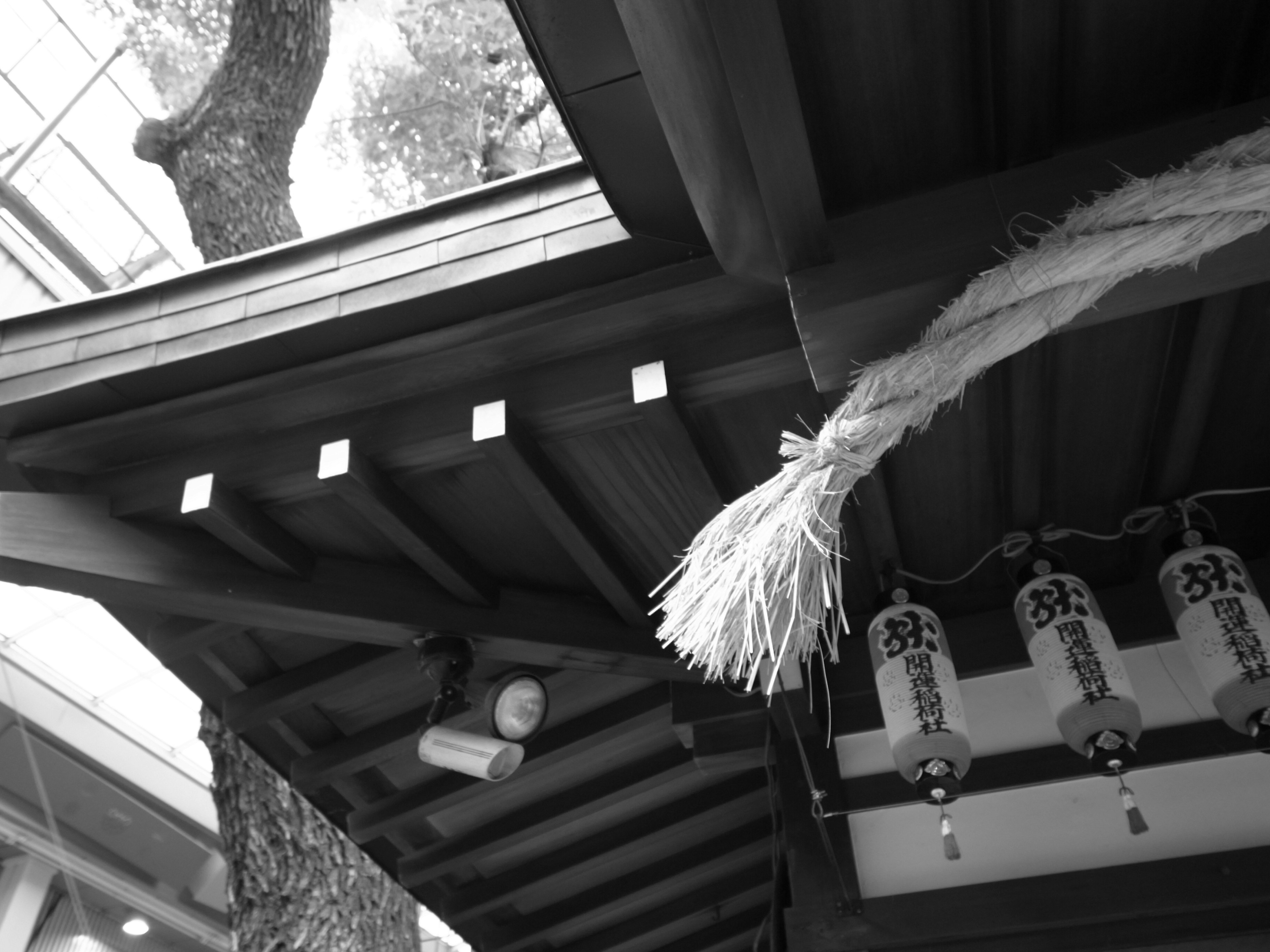 Part of a traditional Japanese building featuring roof decorations and lanterns