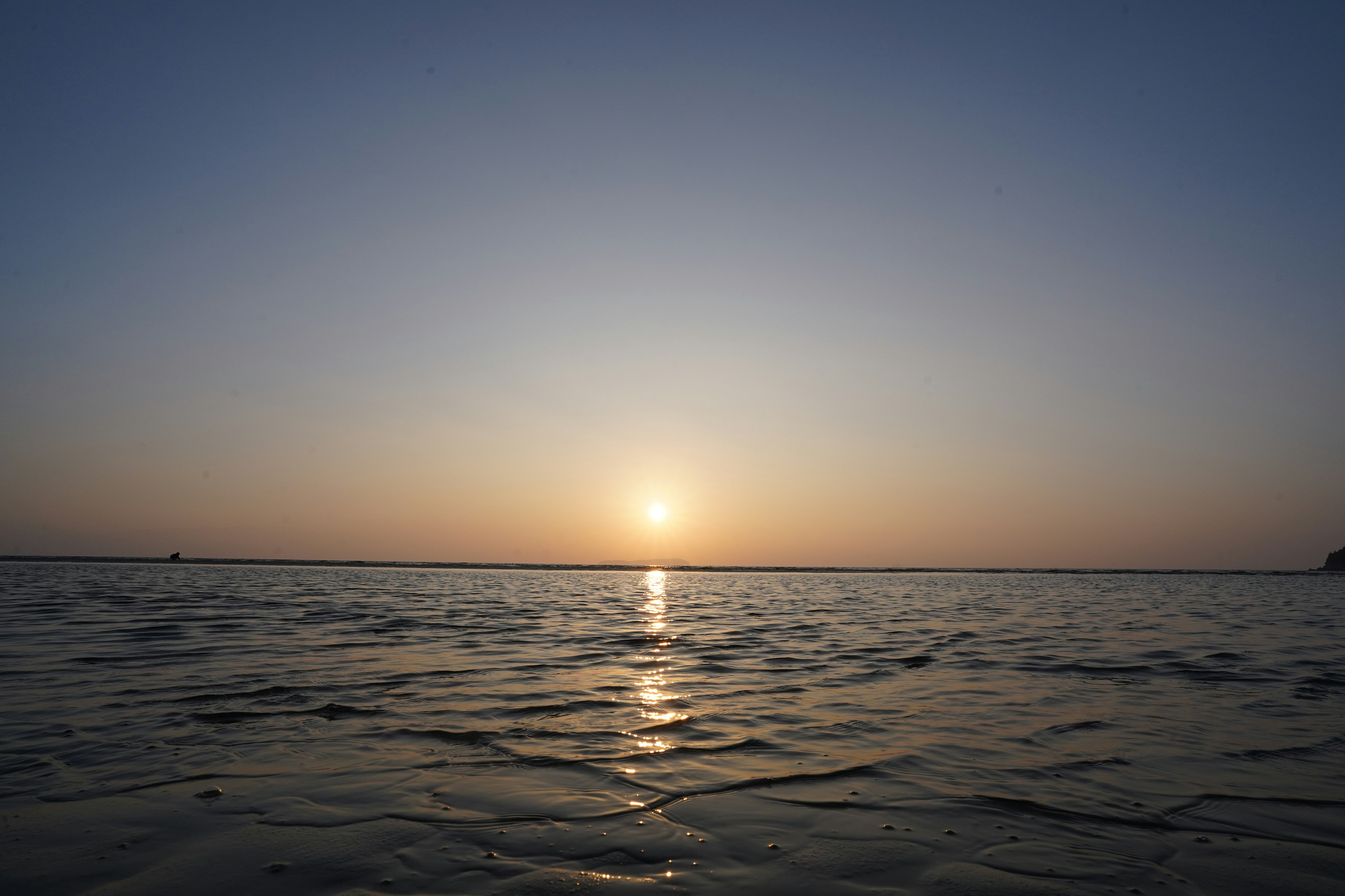 Eine ruhige Aussicht auf den Sonnenuntergang über ruhigen Gewässern