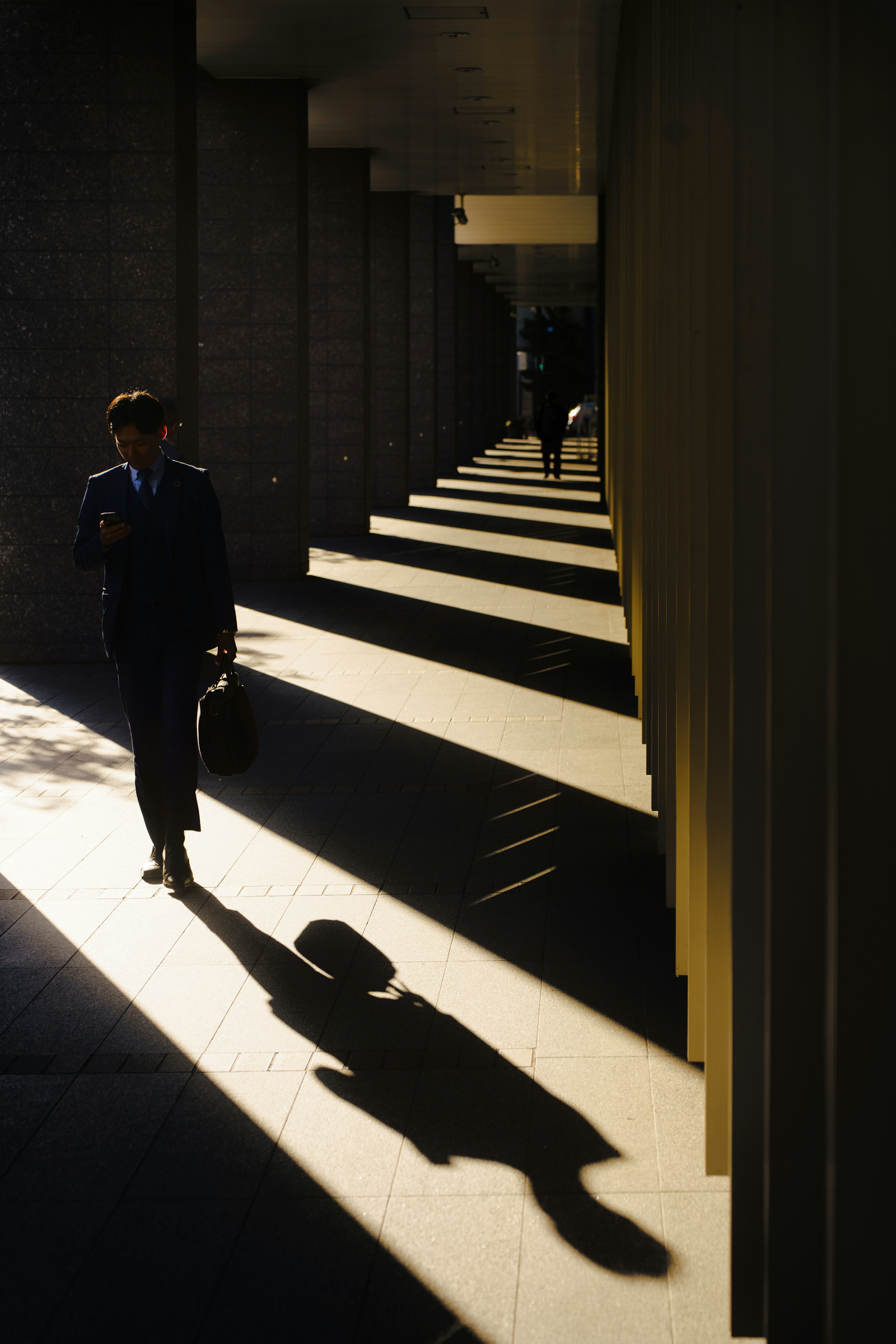 Un homme d'affaires marchant avec une ombre Le contraste lumineux et ombragé est frappant