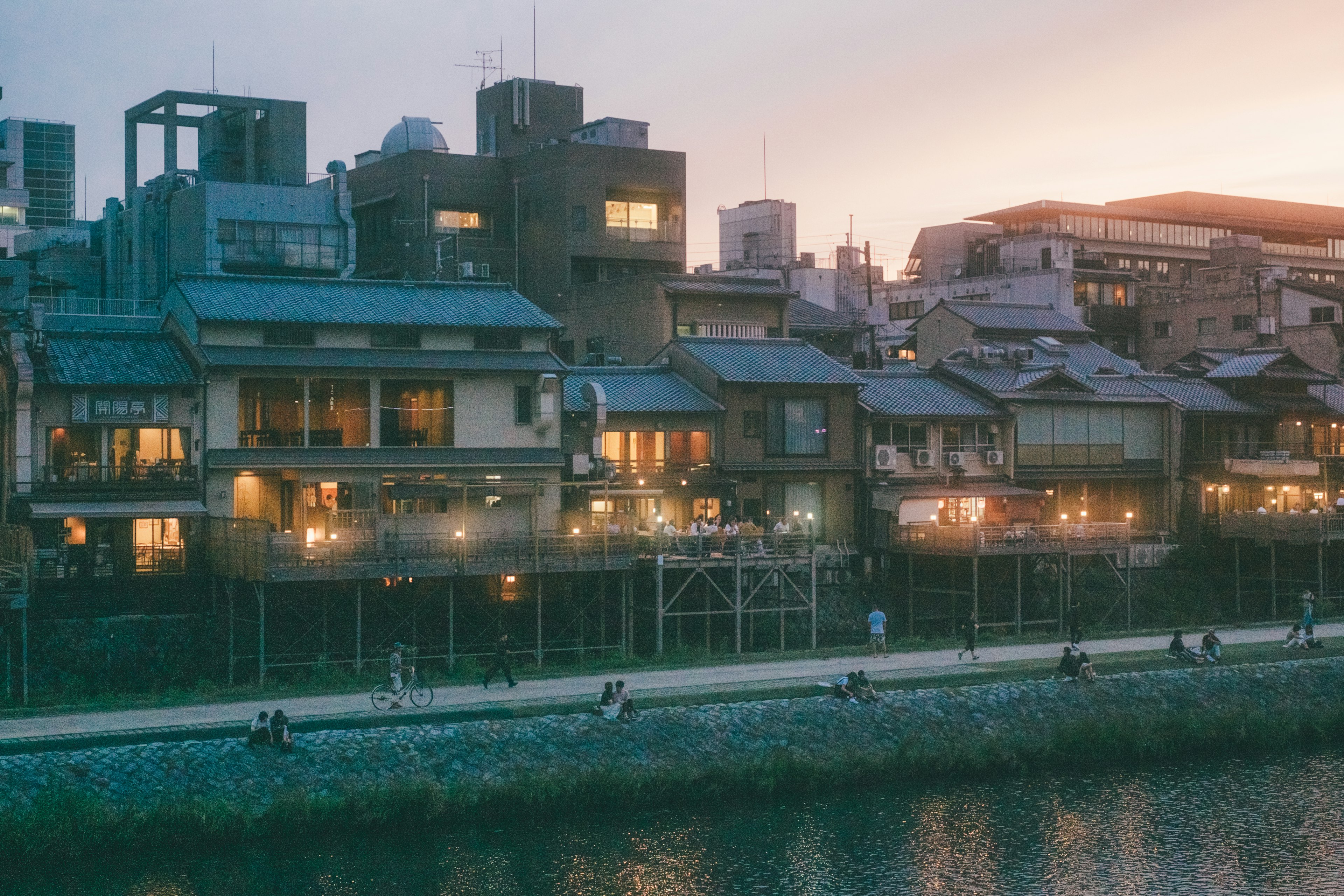 Traditional Japanese townhouses along a riverside at dusk