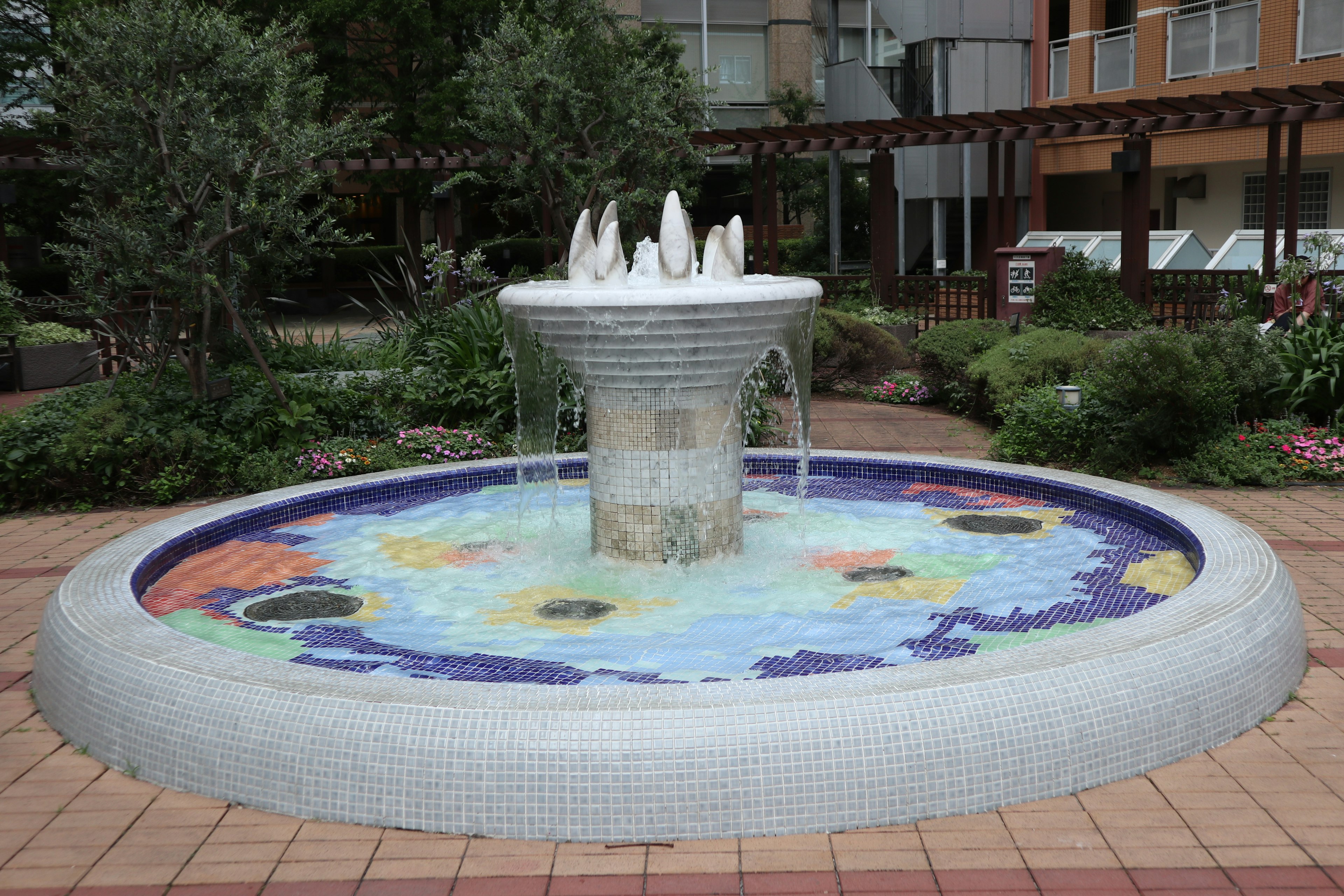 Colorful mosaic tile fountain in a garden setting