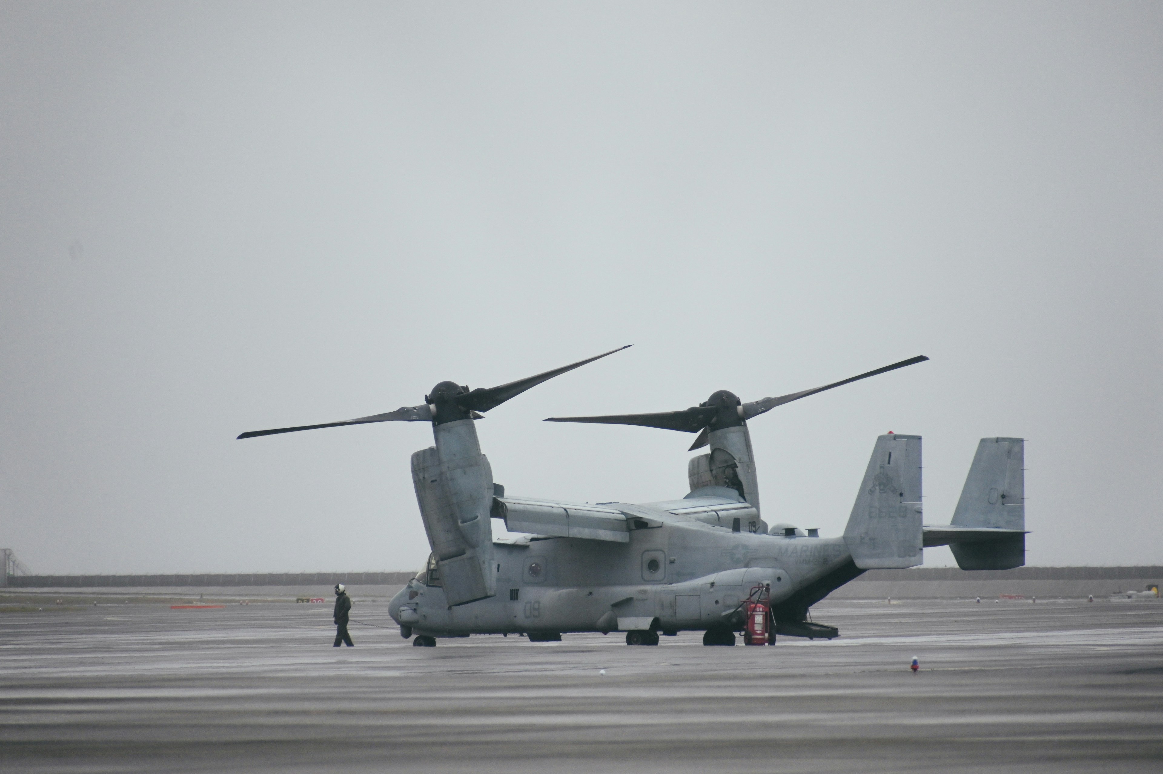 Aereo Osprey parcheggiato sulla pista con il paesaggio circostante