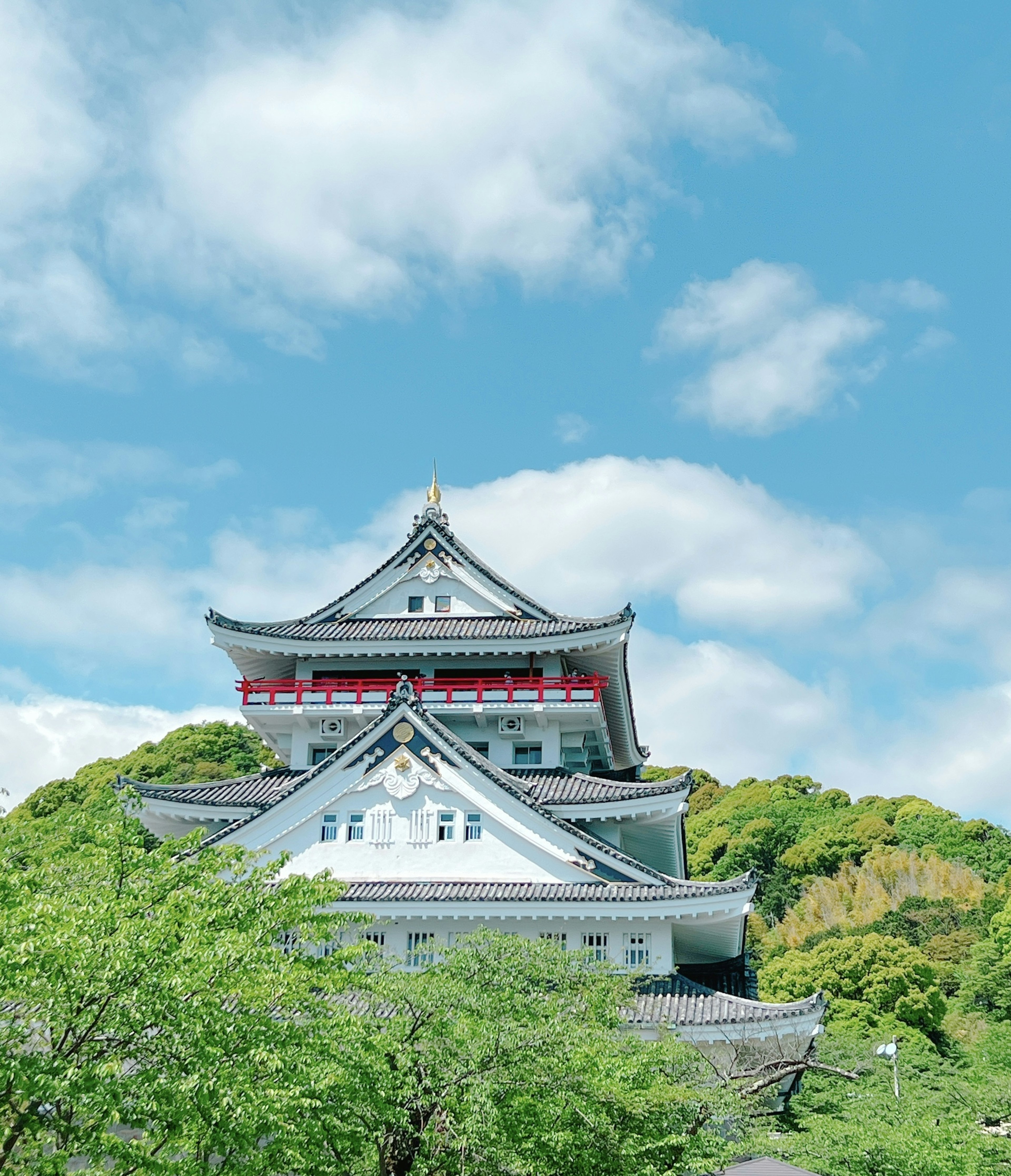 Kastil Jepang yang indah di bawah langit biru dan pohon hijau