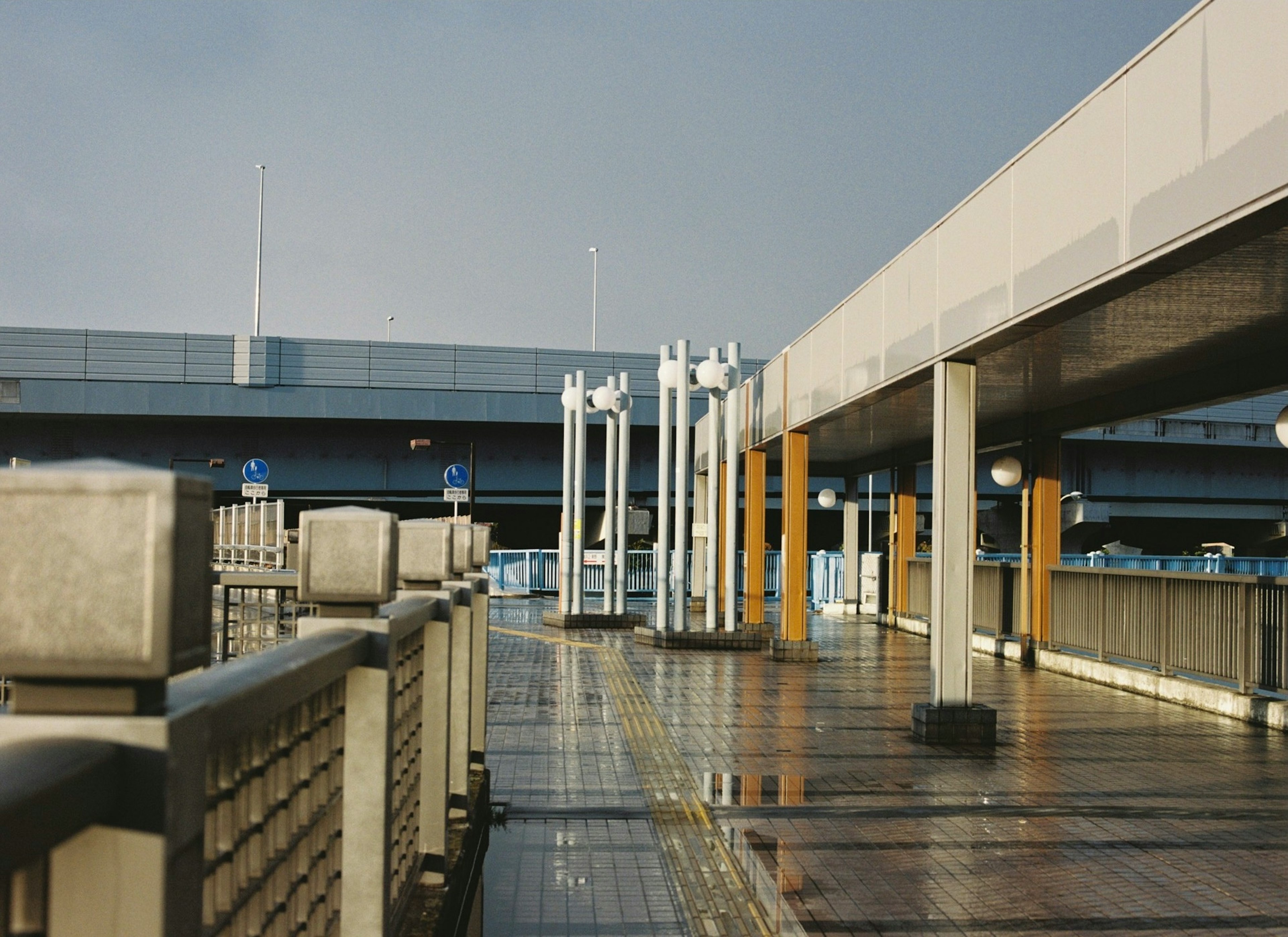 Wide walkway with modern architecture and wet surfaces after rain