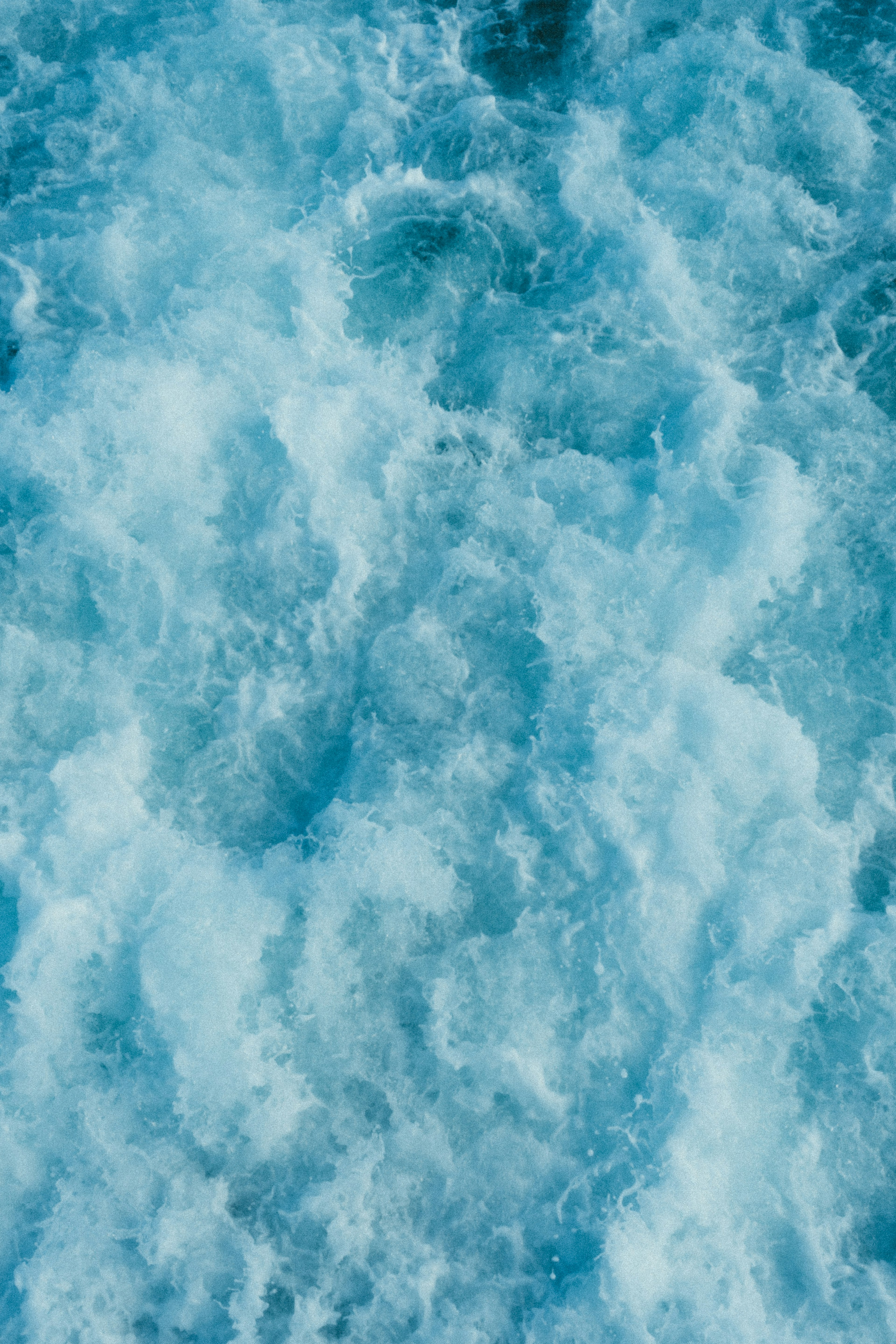 Textured blue water with waves and bubbles