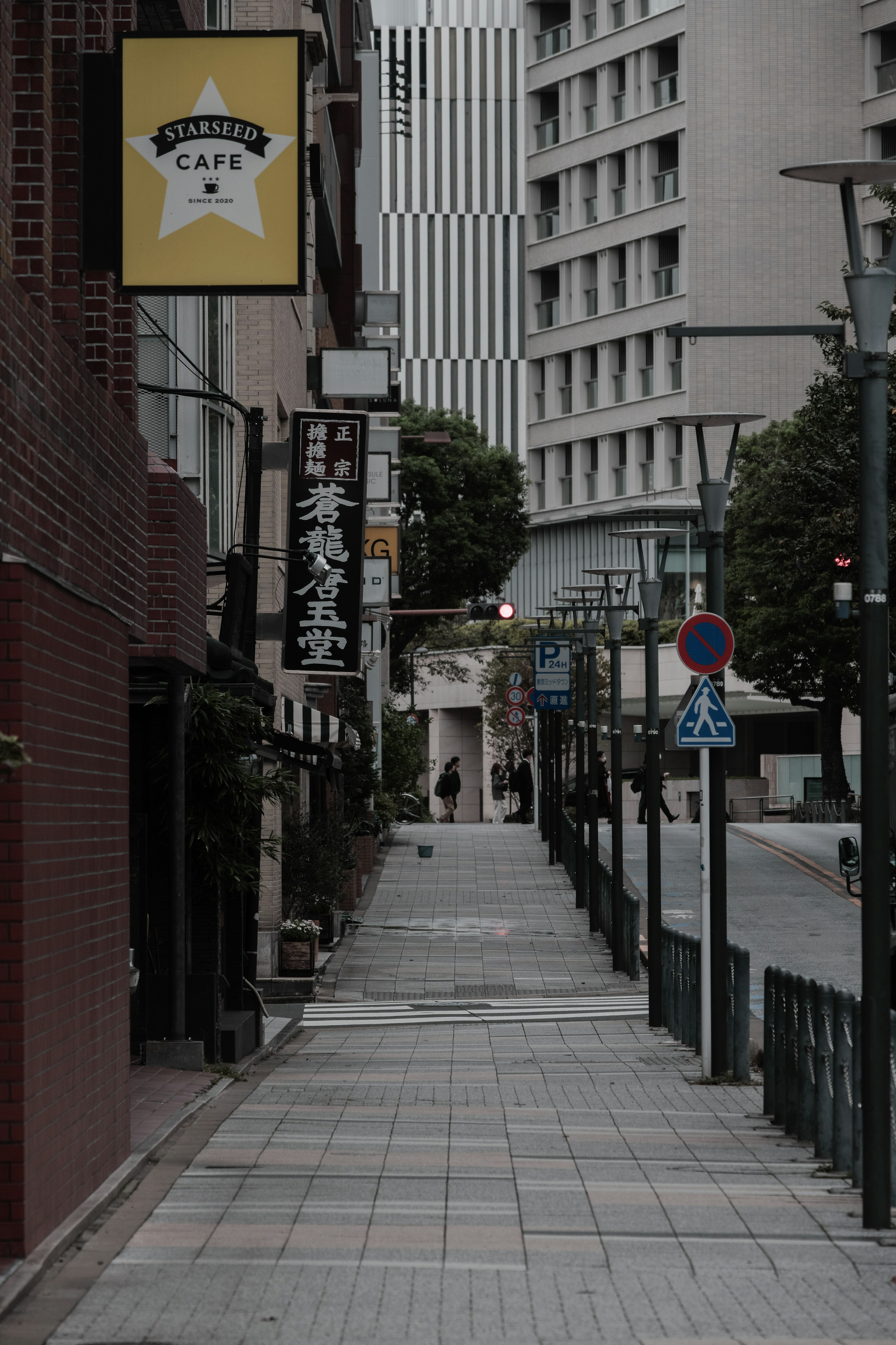 Trottoir pavé le long d'une rue urbaine calme avec des enseignes commerciales