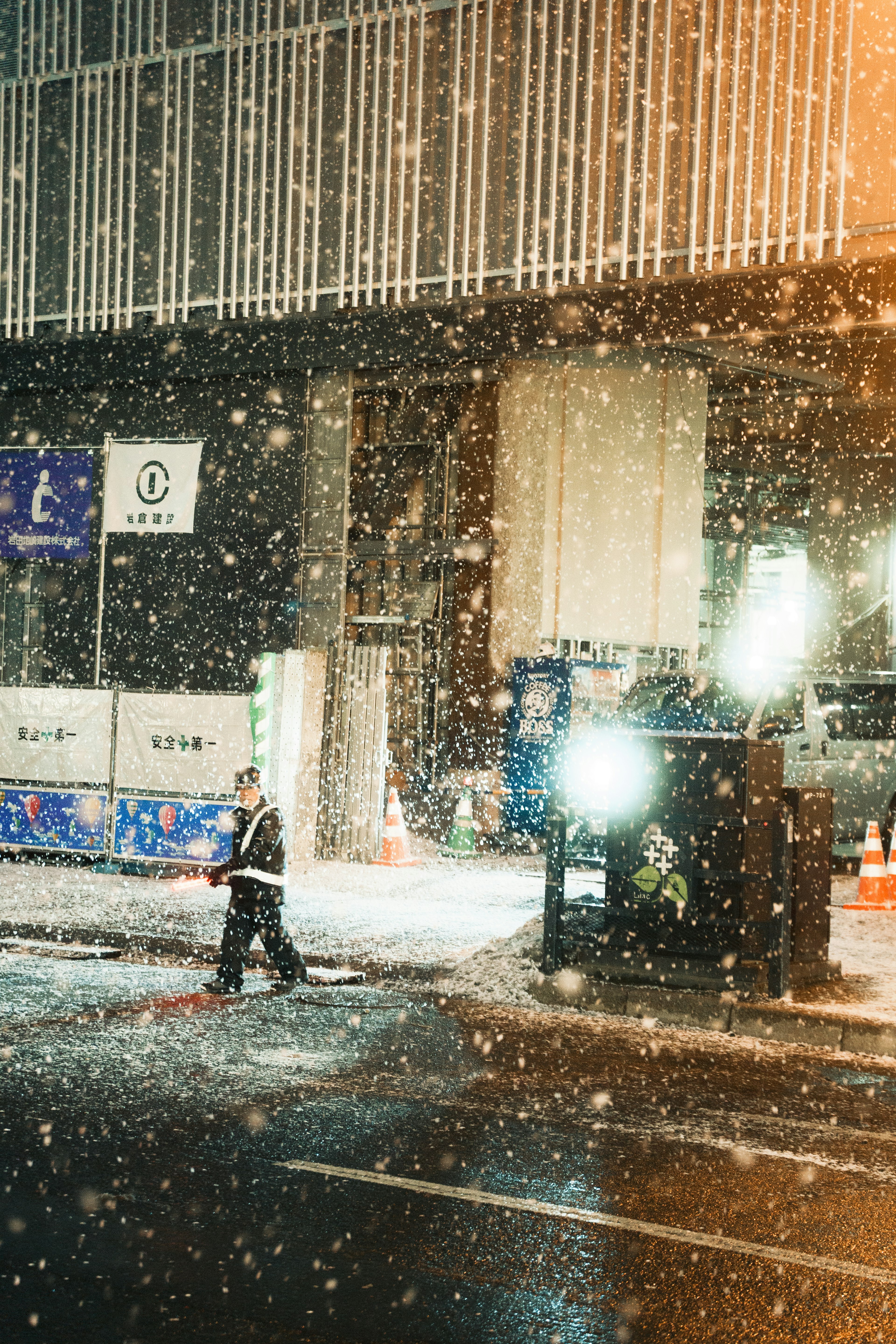 Ouvrier dans une rue enneigée la nuit avec des lumières vives