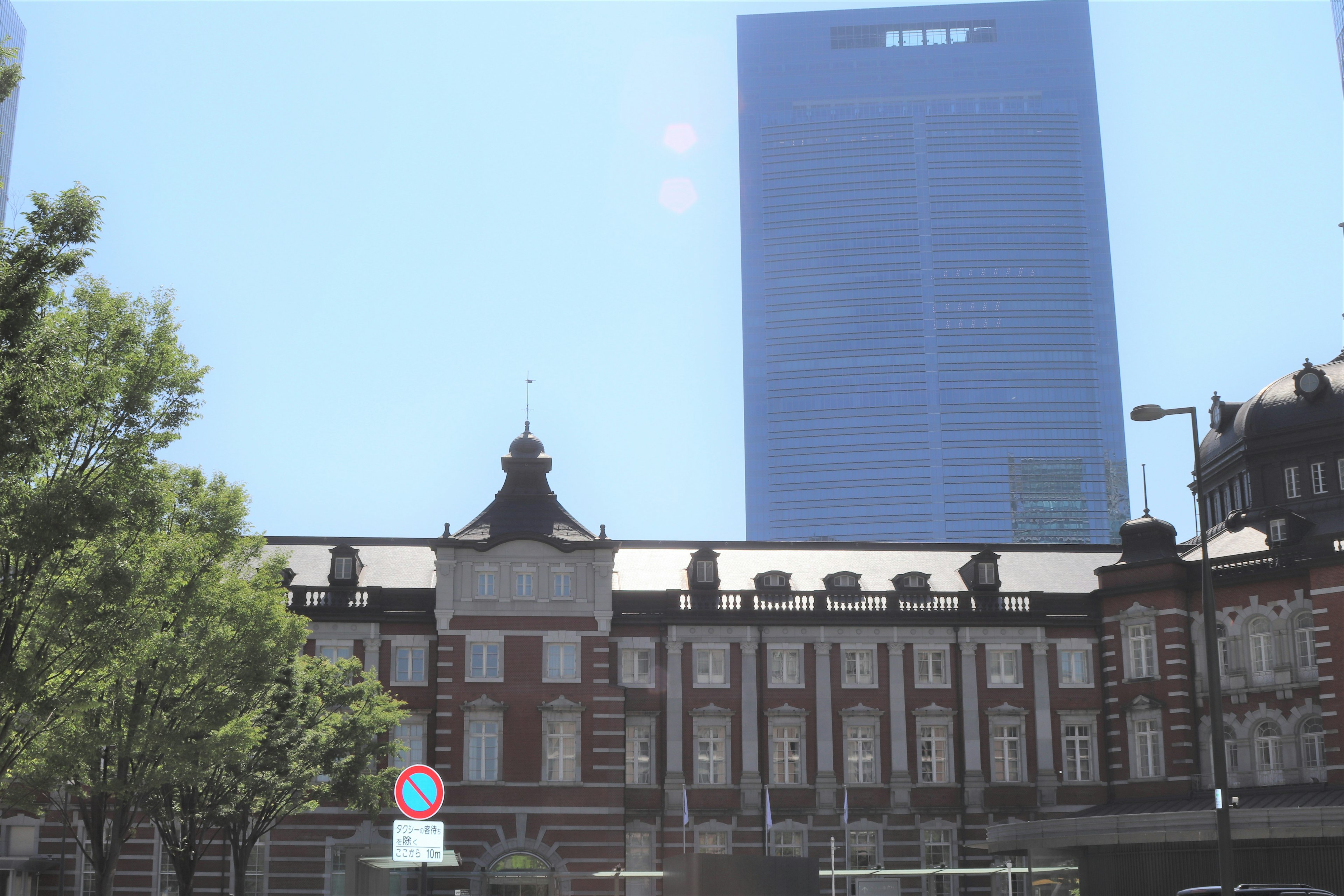 L'architecture historique de la gare de Tokyo contrastée avec un gratte-ciel moderne