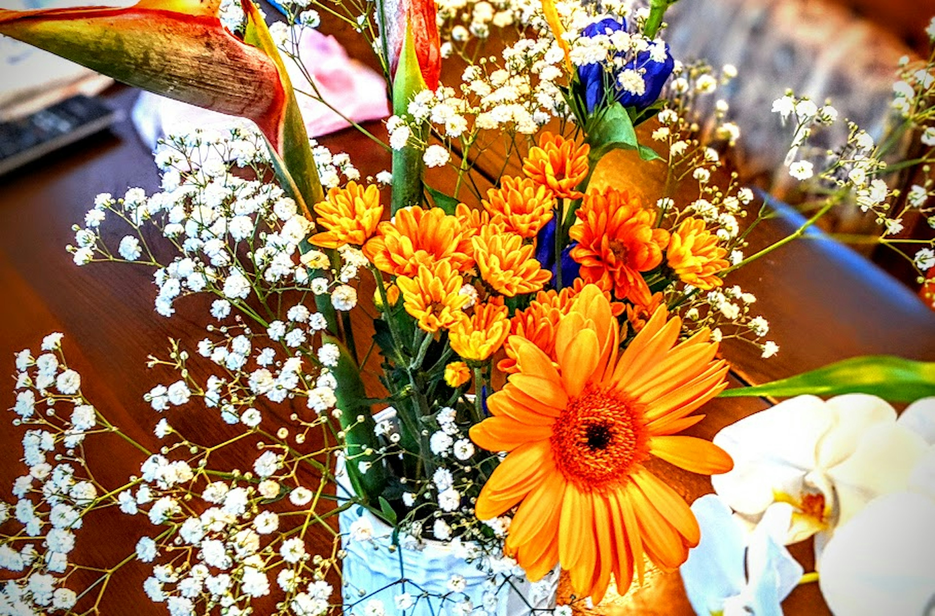 Bouquet avec des marguerites gerbera orange et de l'herbe à bébé blanche