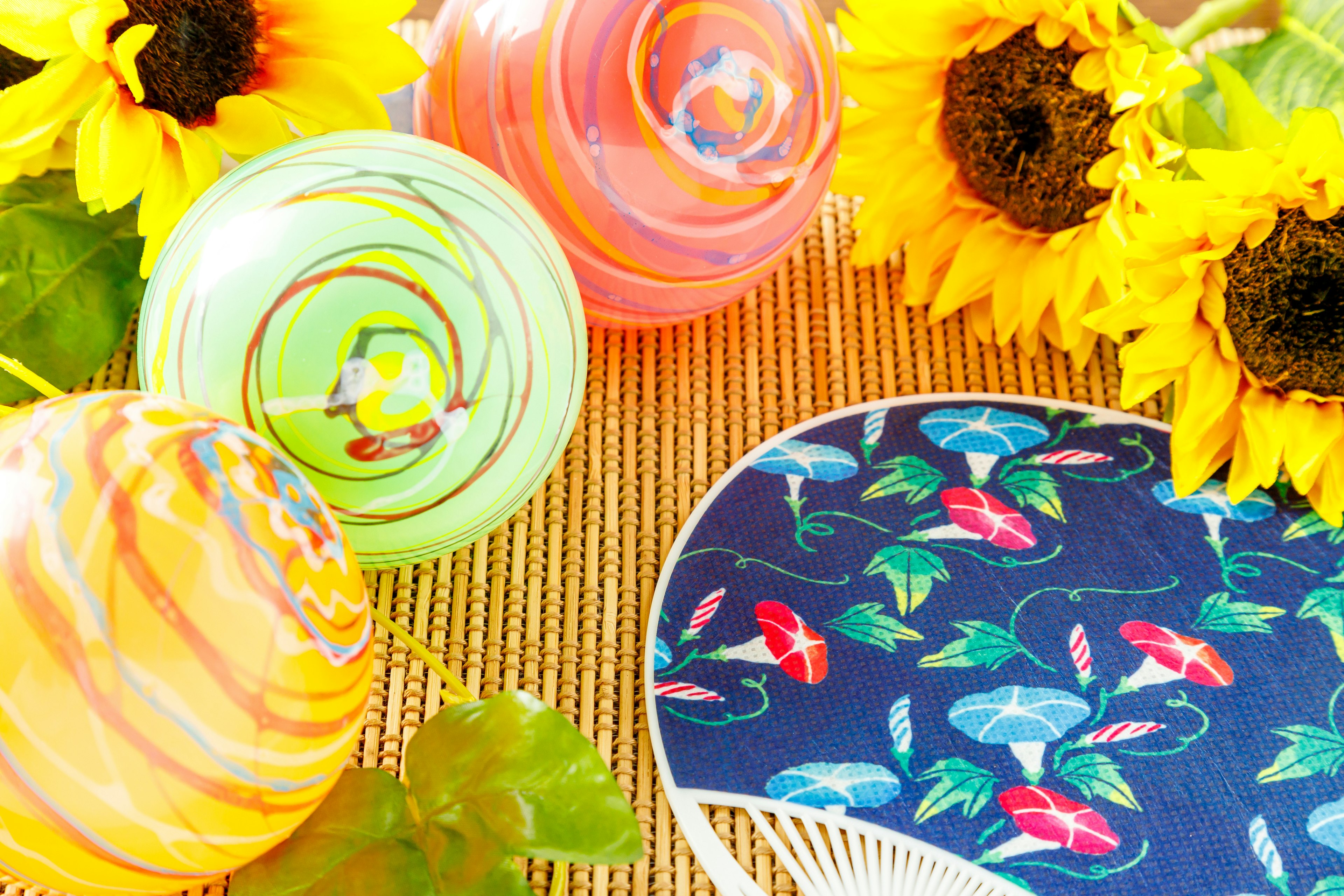 Colorful marbles and a fan surrounded by sunflowers