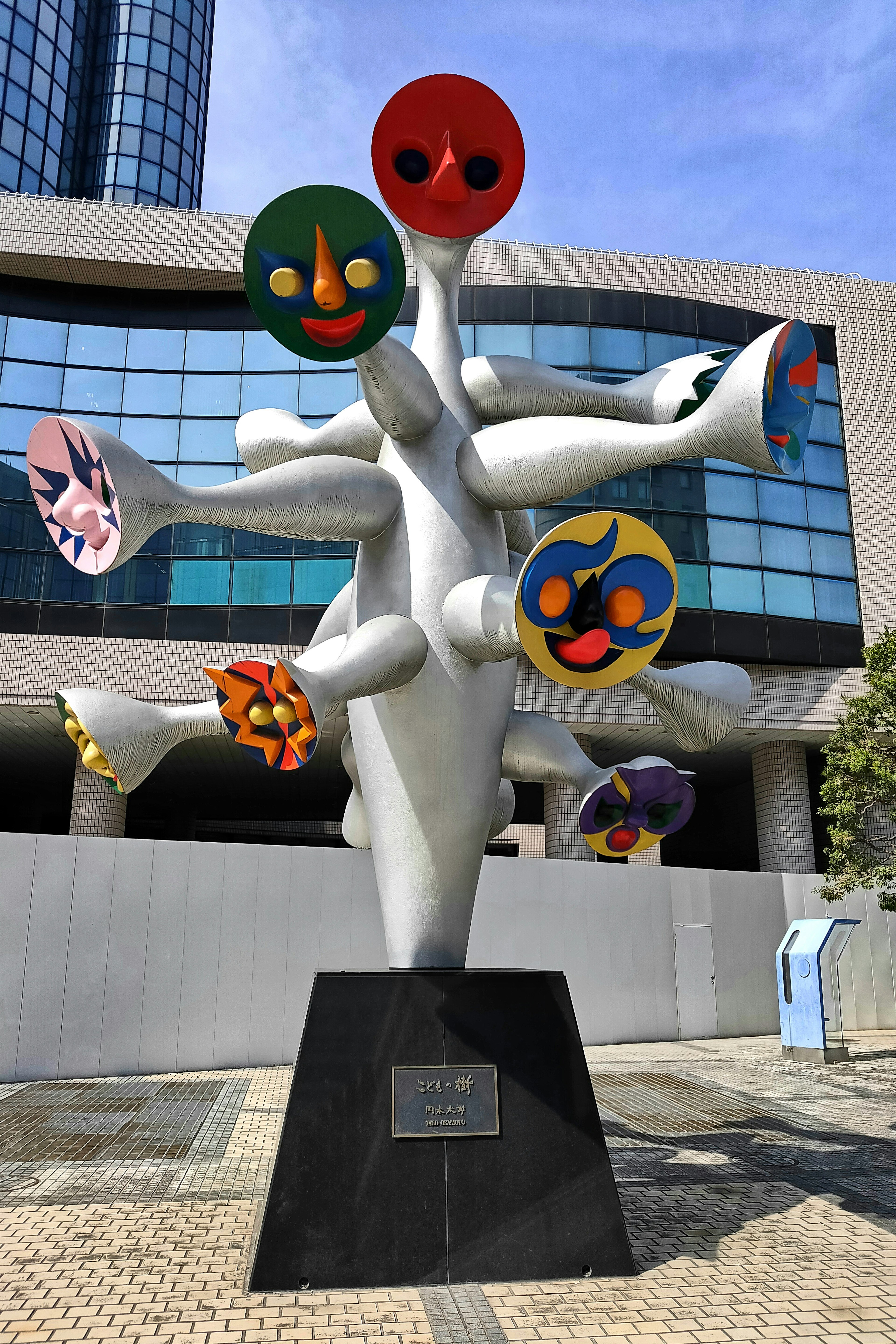 Abstract sculpture with colorful faces on a twisting structure