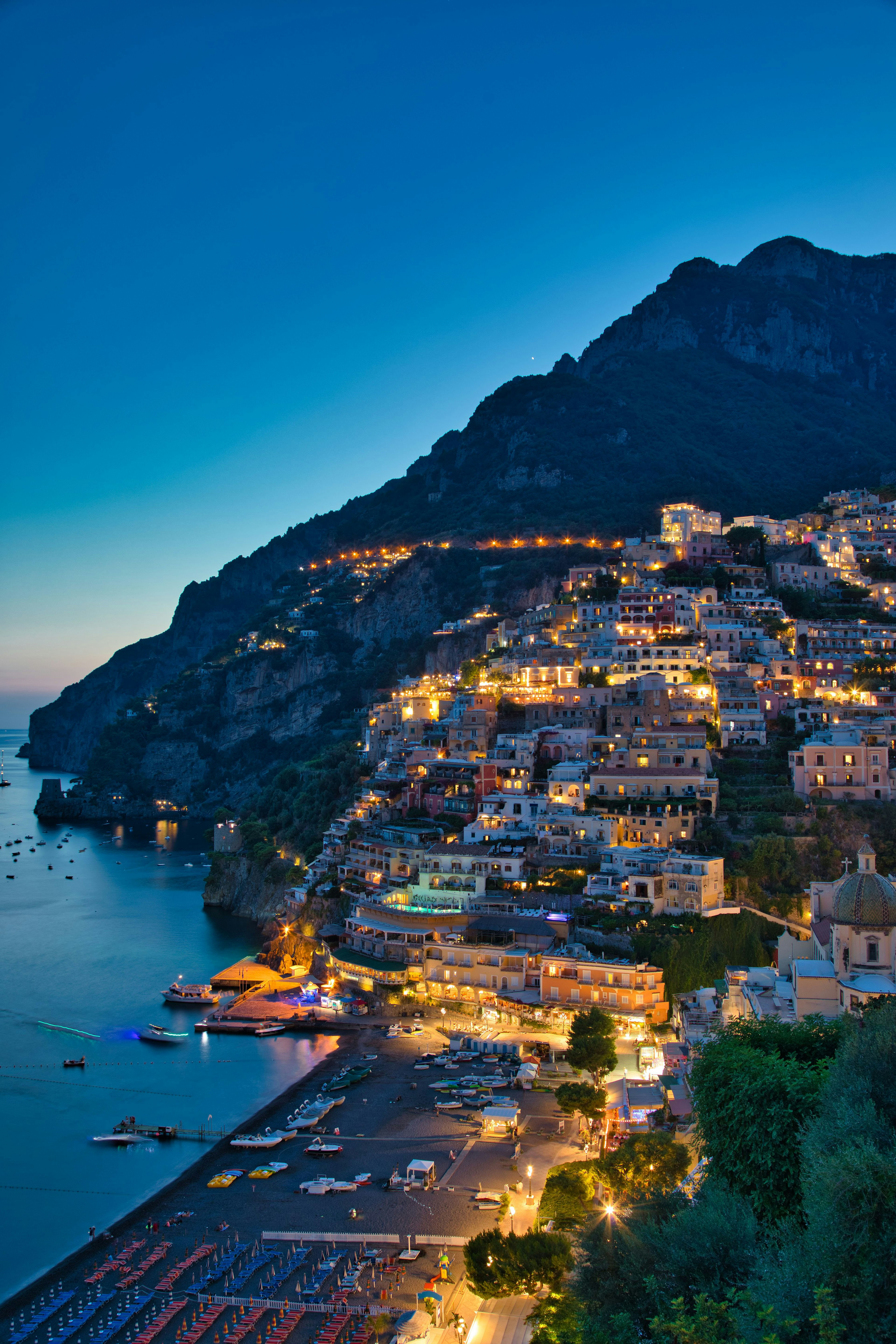 Schöne Küstenansicht von Positano bei Nacht mit beleuchteten Gebäuden