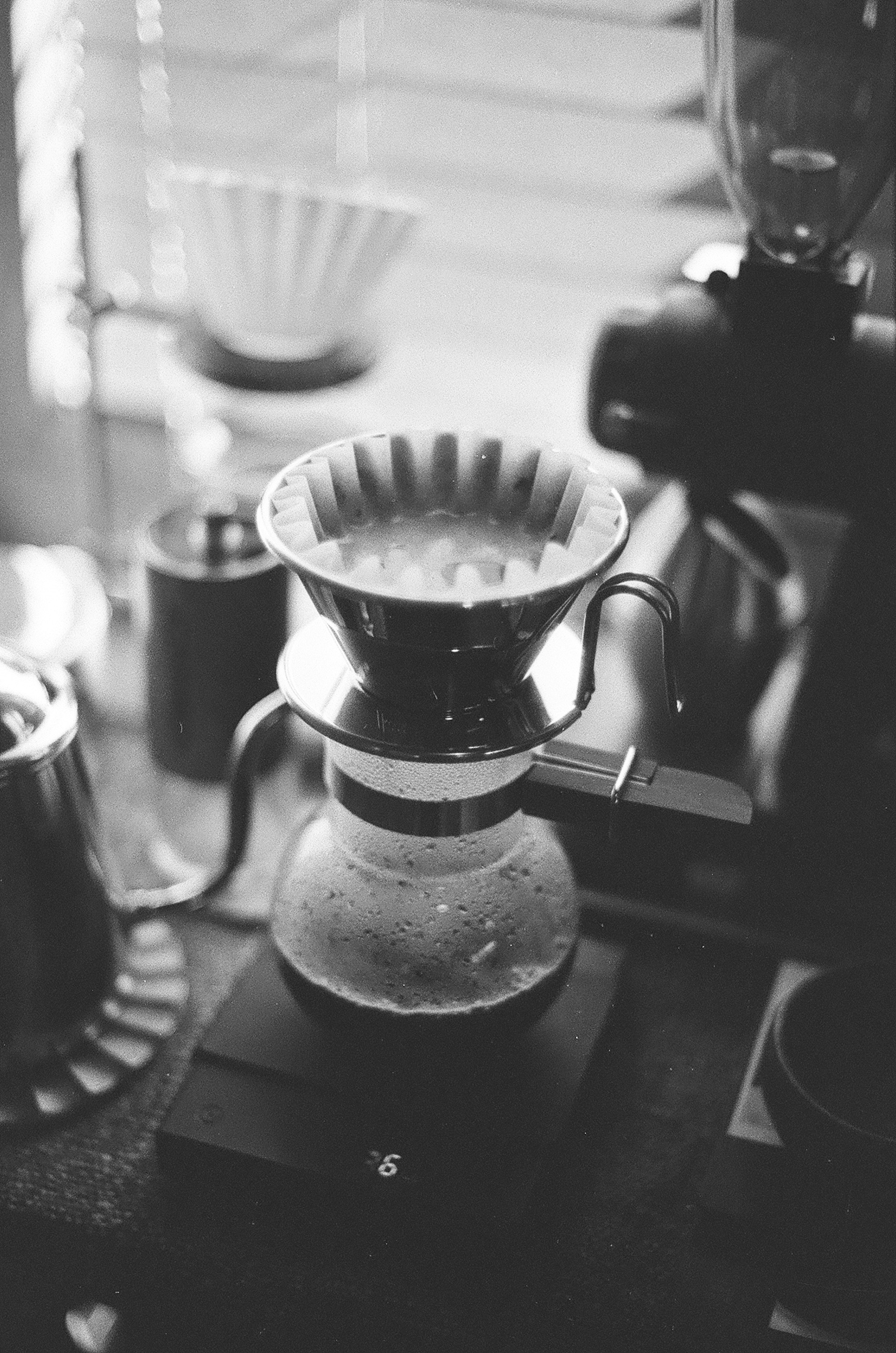 Scène de cuisine en noir et blanc avec un filtre à café et du matériel de préparation