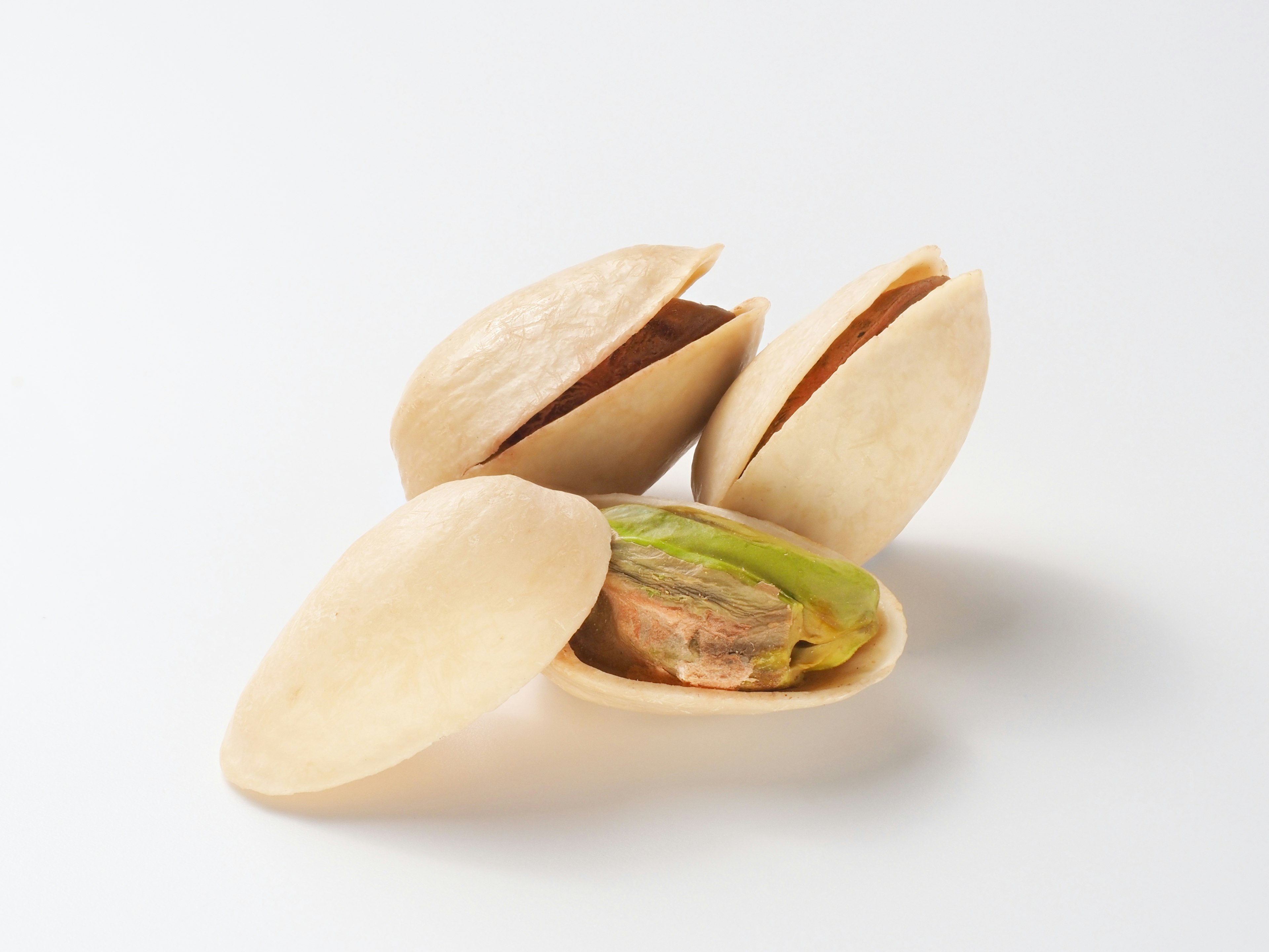 Open pistachio shells revealing green nuts inside