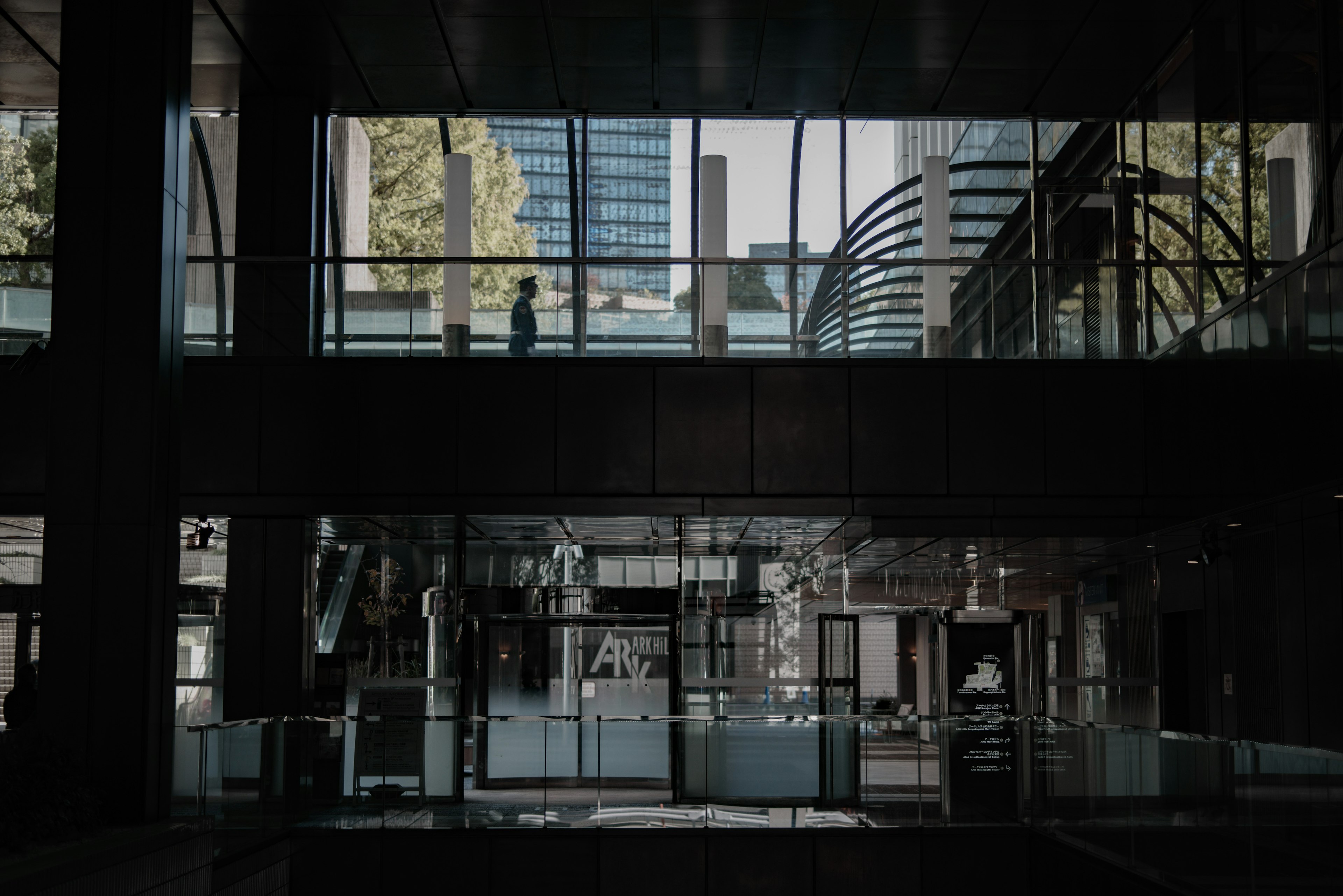 Intérieur d'un bâtiment de bureau moderne visible à travers des murs en verre avec un paysage urbain