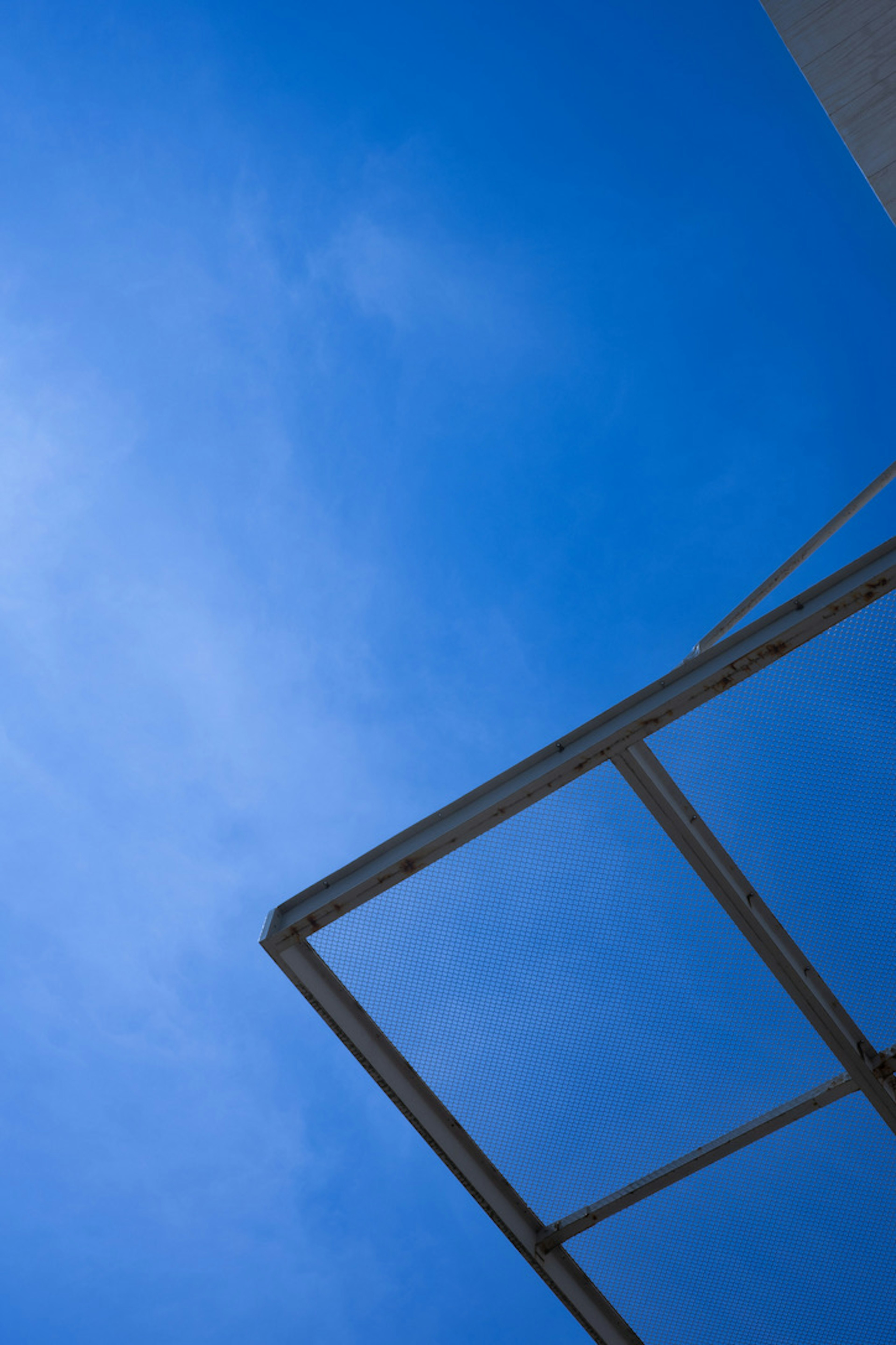 Immagine con cielo blu chiaro e angolo di un edificio