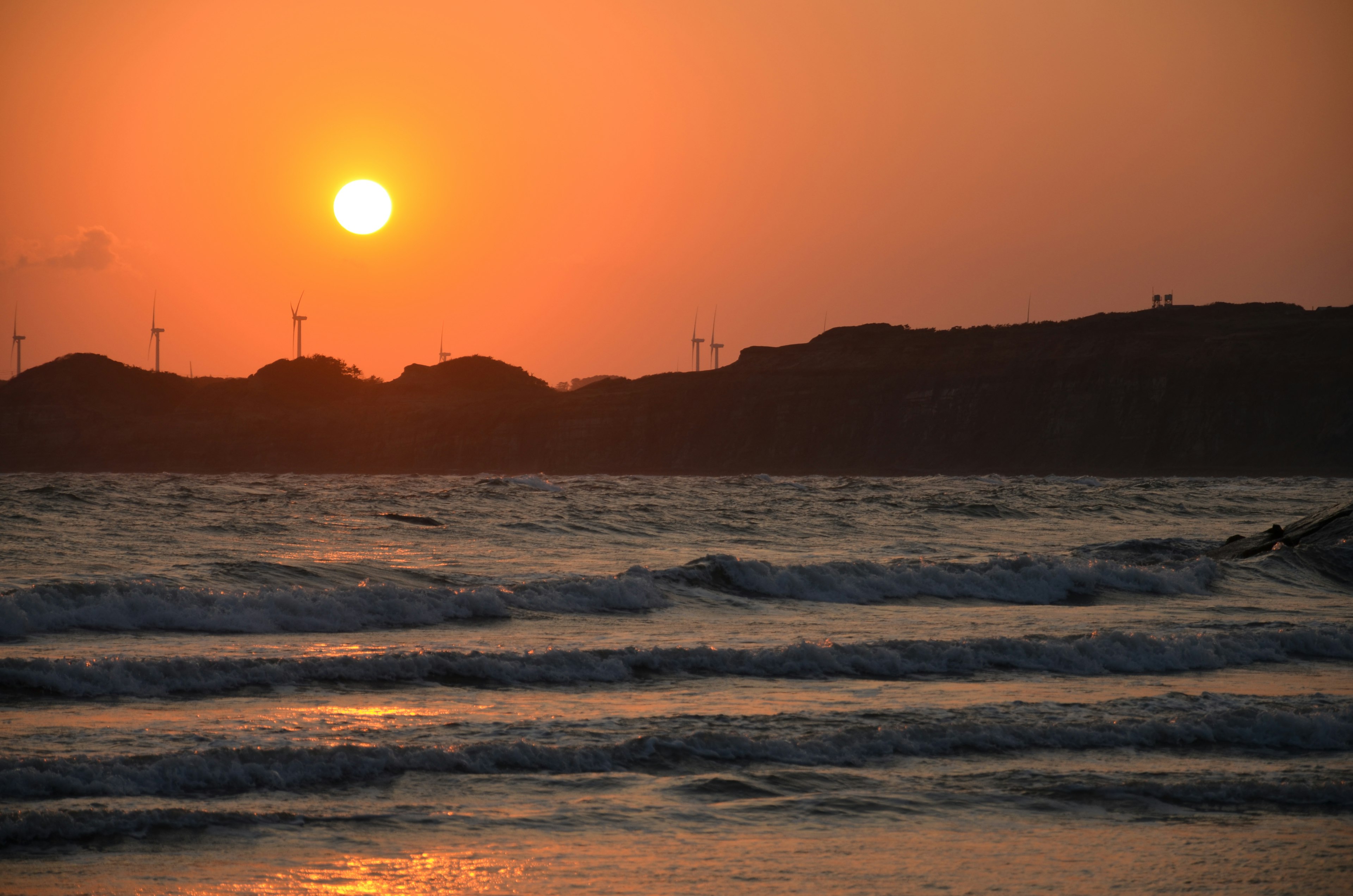 夕日が海に沈む美しい風景波が穏やかに押し寄せている