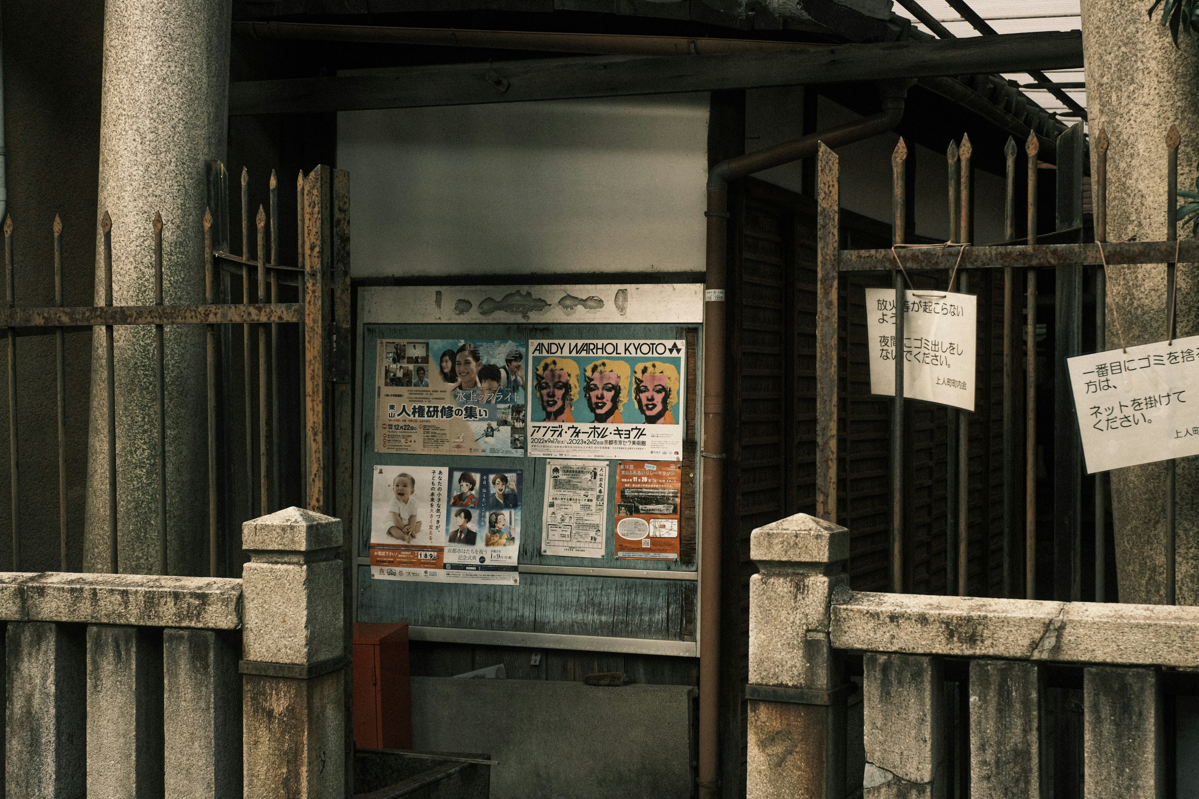 Entrada con una puerta antigua y un tablón de anuncios