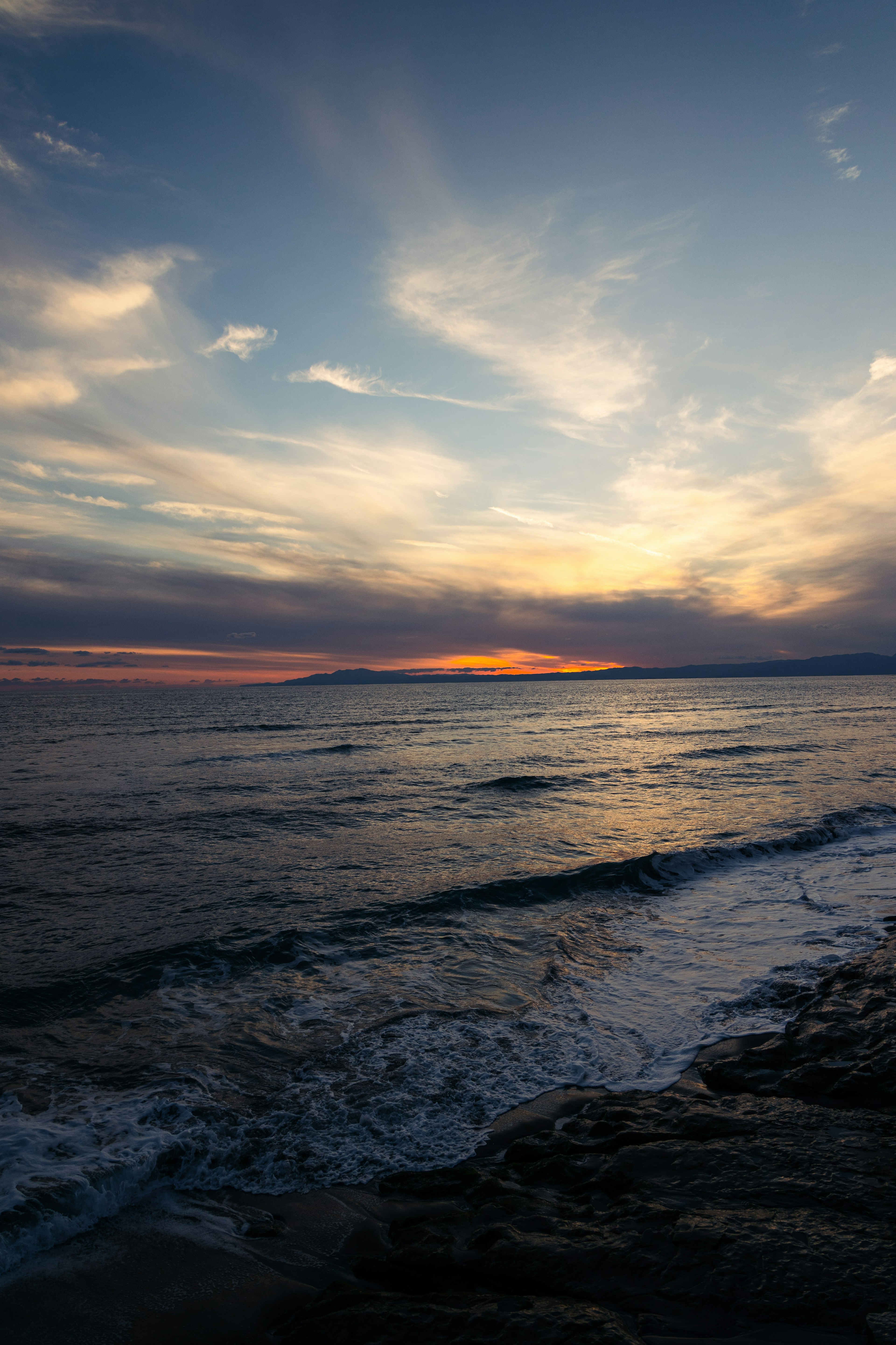 夕暮れの海の風景、波と空の色彩が美しい