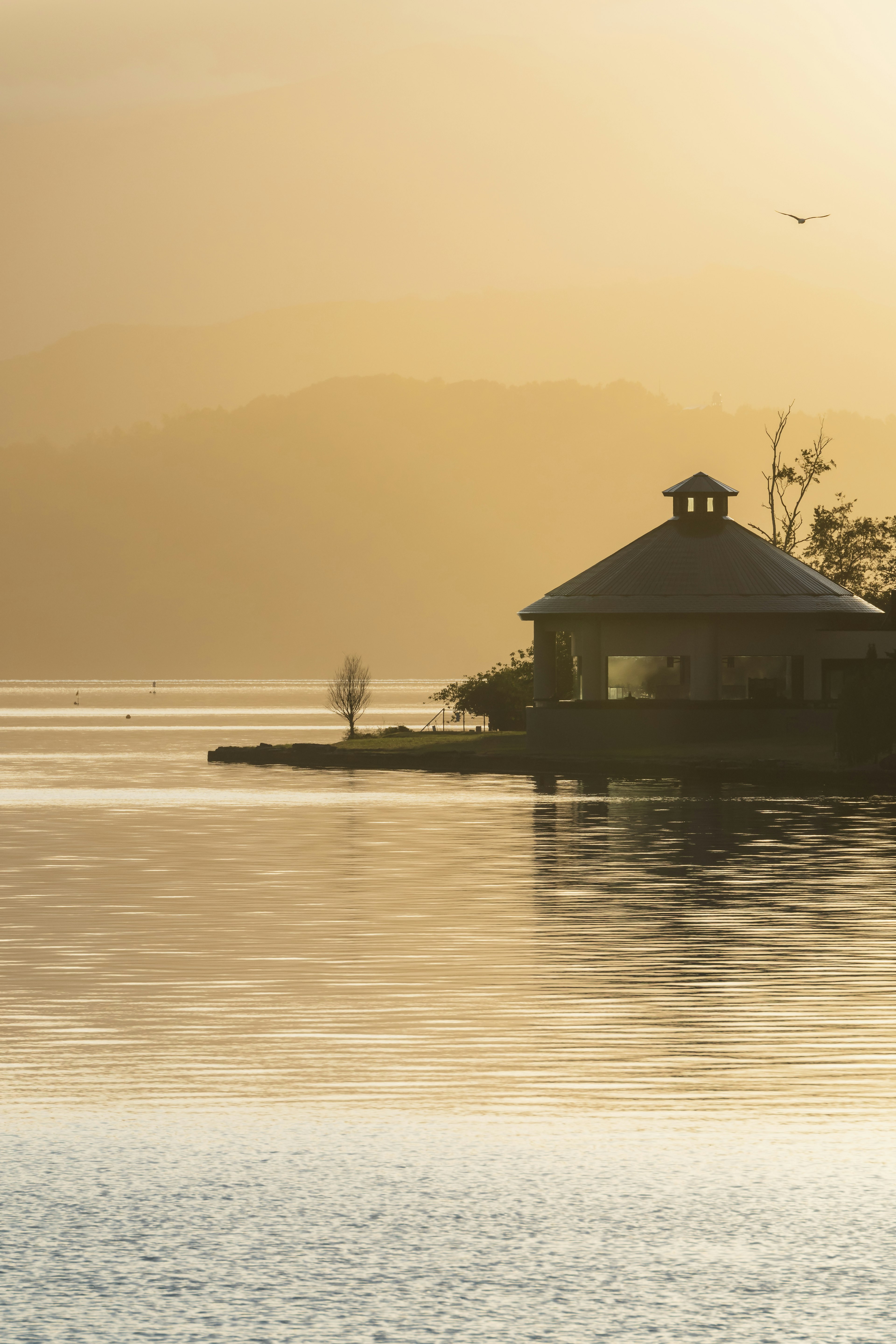 Una cabaña tranquila junto al lago con una silueta de montañas al fondo