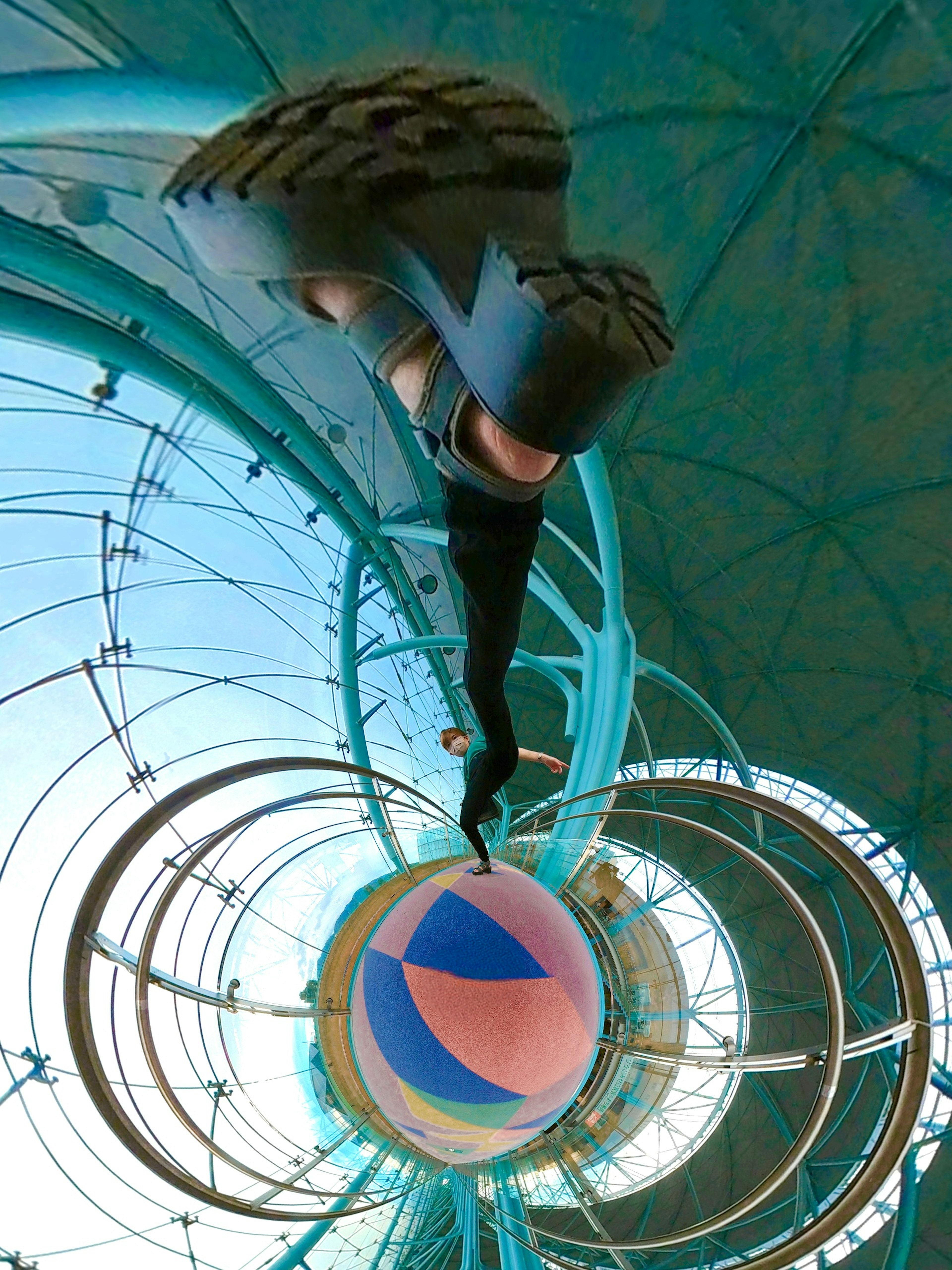 A person's foot above a colorful ball with a blue background