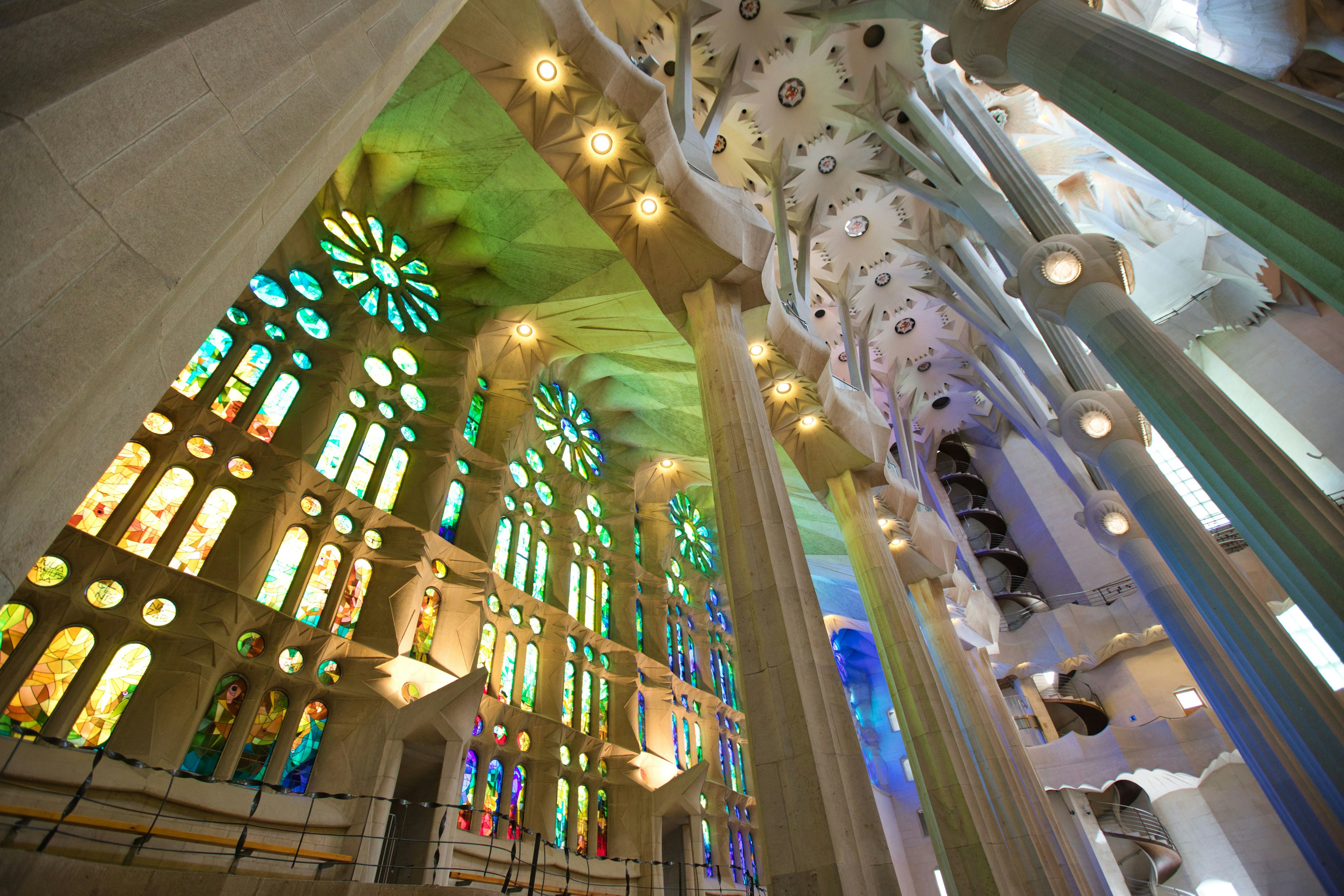 Interior de la Sagrada Familia con vitrales coloridos y columnas únicas