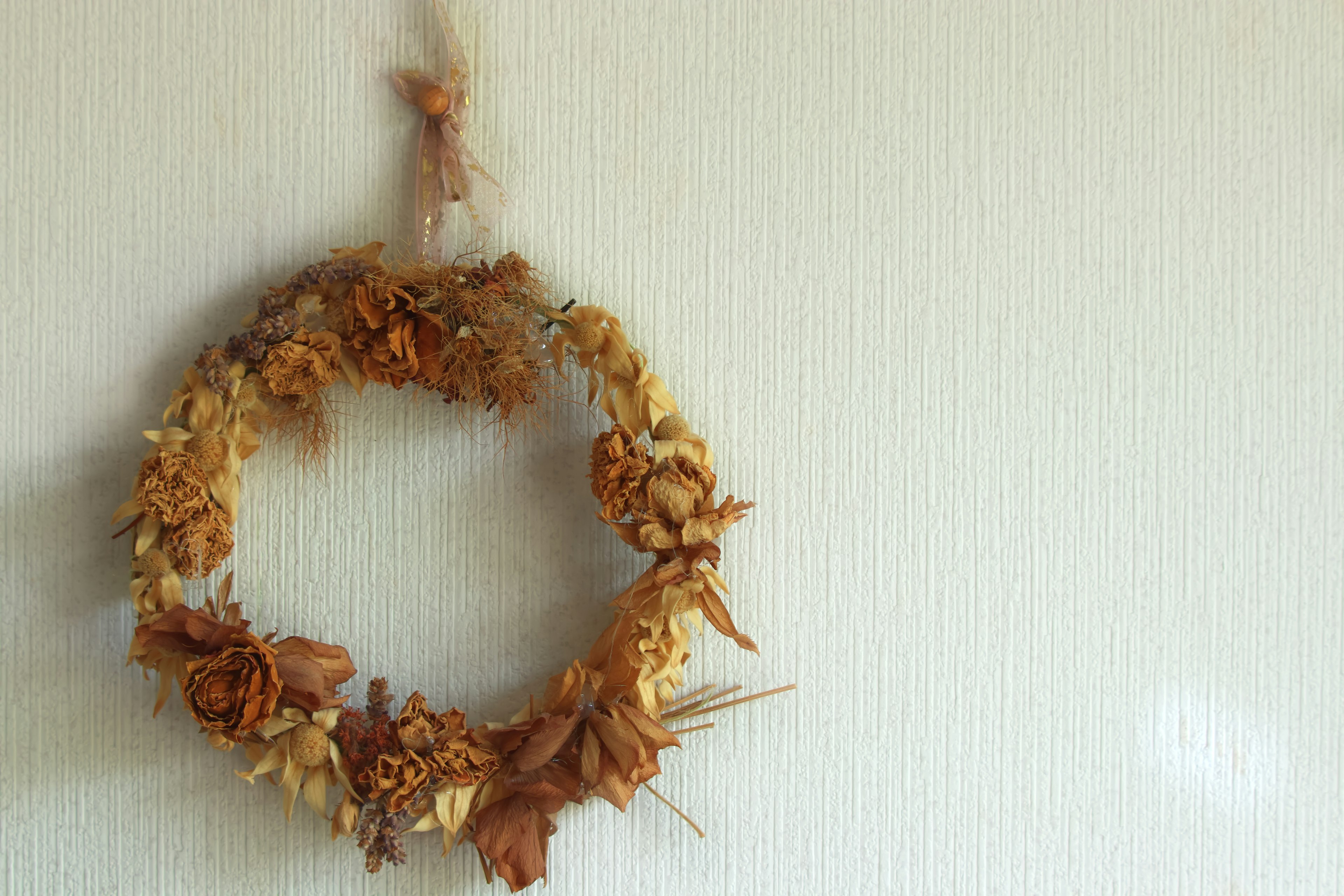 A dried flower wreath hanging on a wall