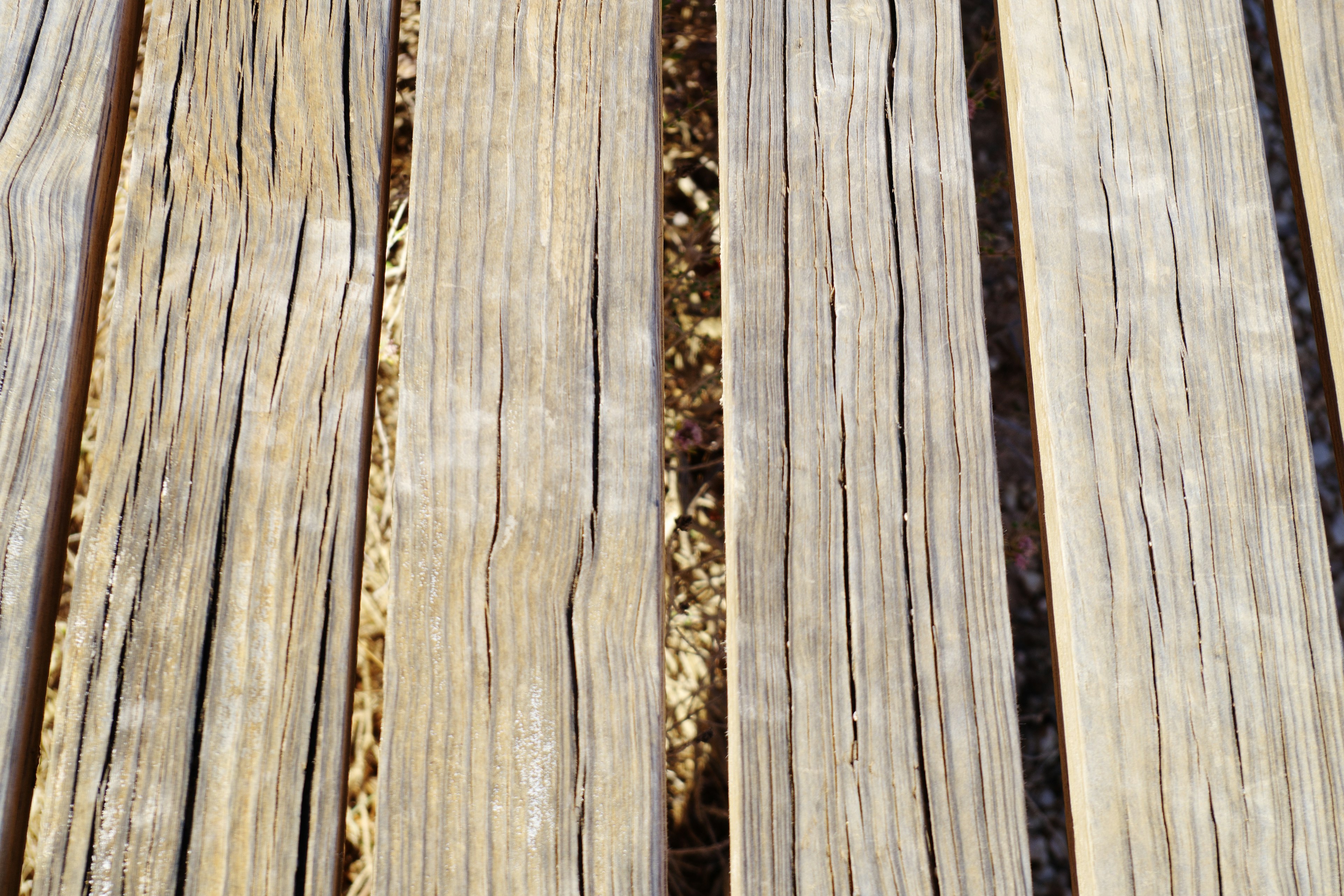 Close-up papan kayu dengan pola serat yang terlihat dan nada warna terang