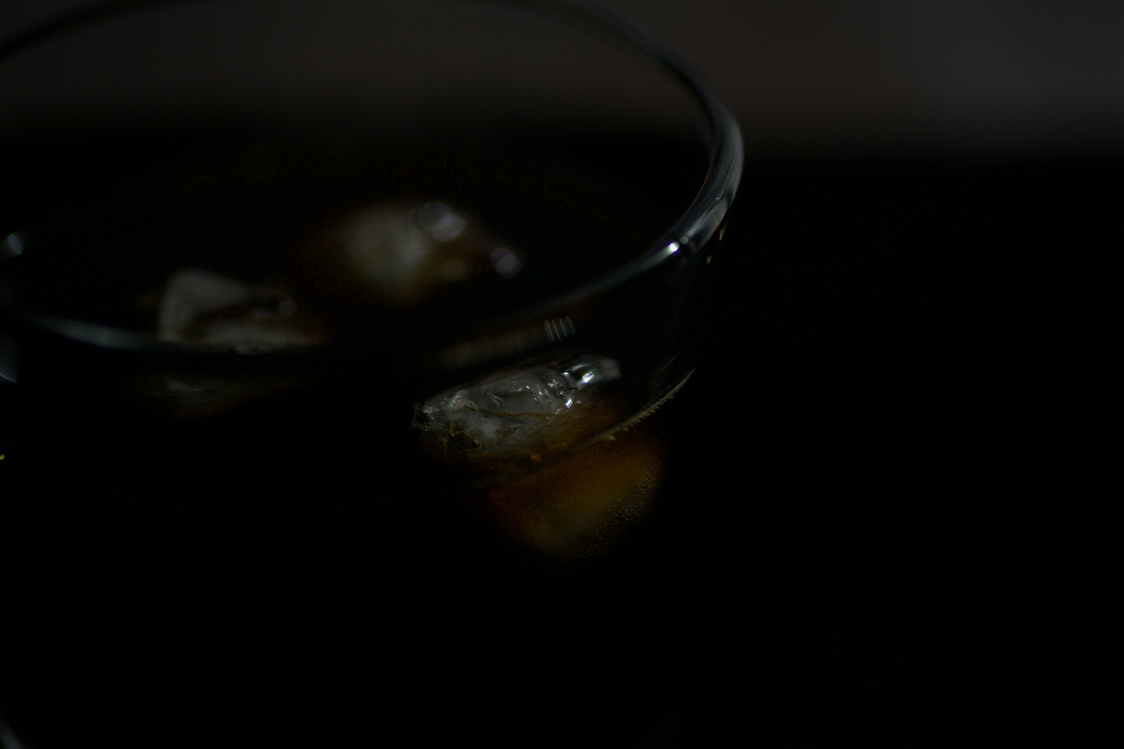 Vaso de bebida oscura con cubitos de hielo