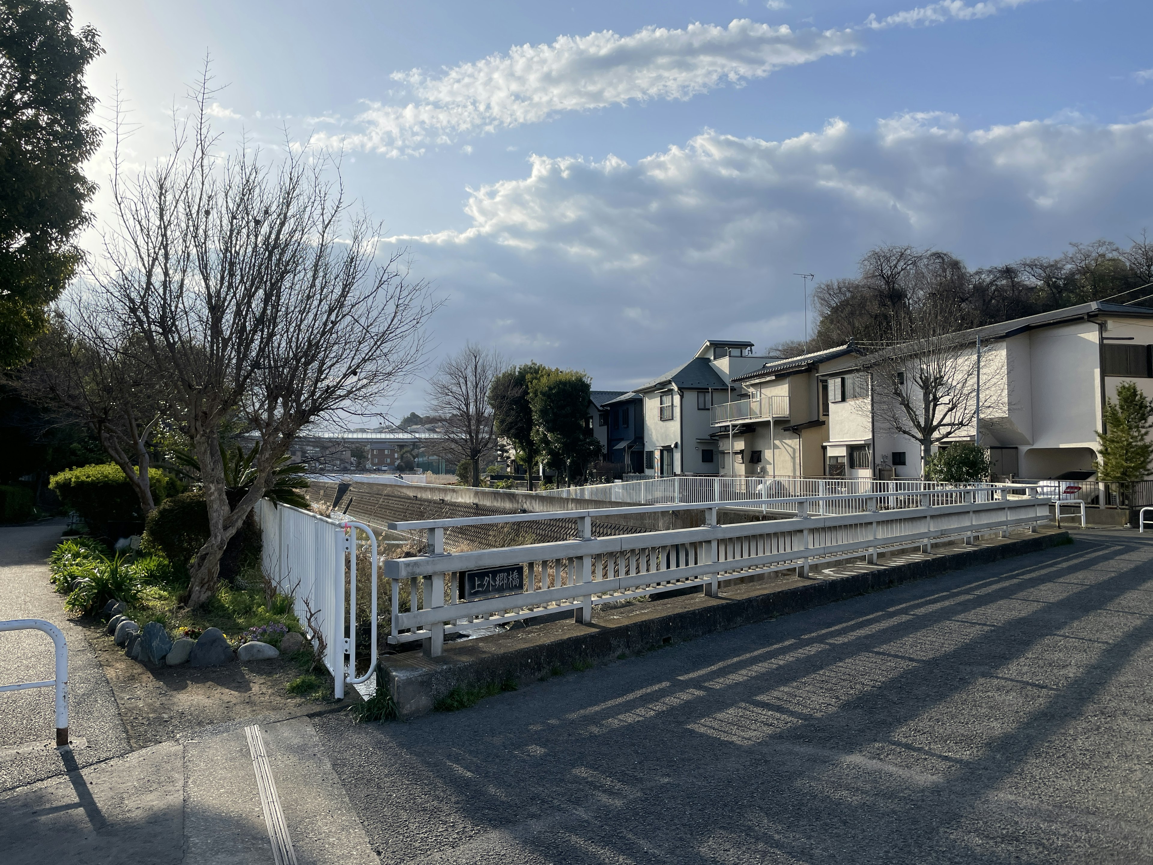 Quiet street view with white fence and residential houses