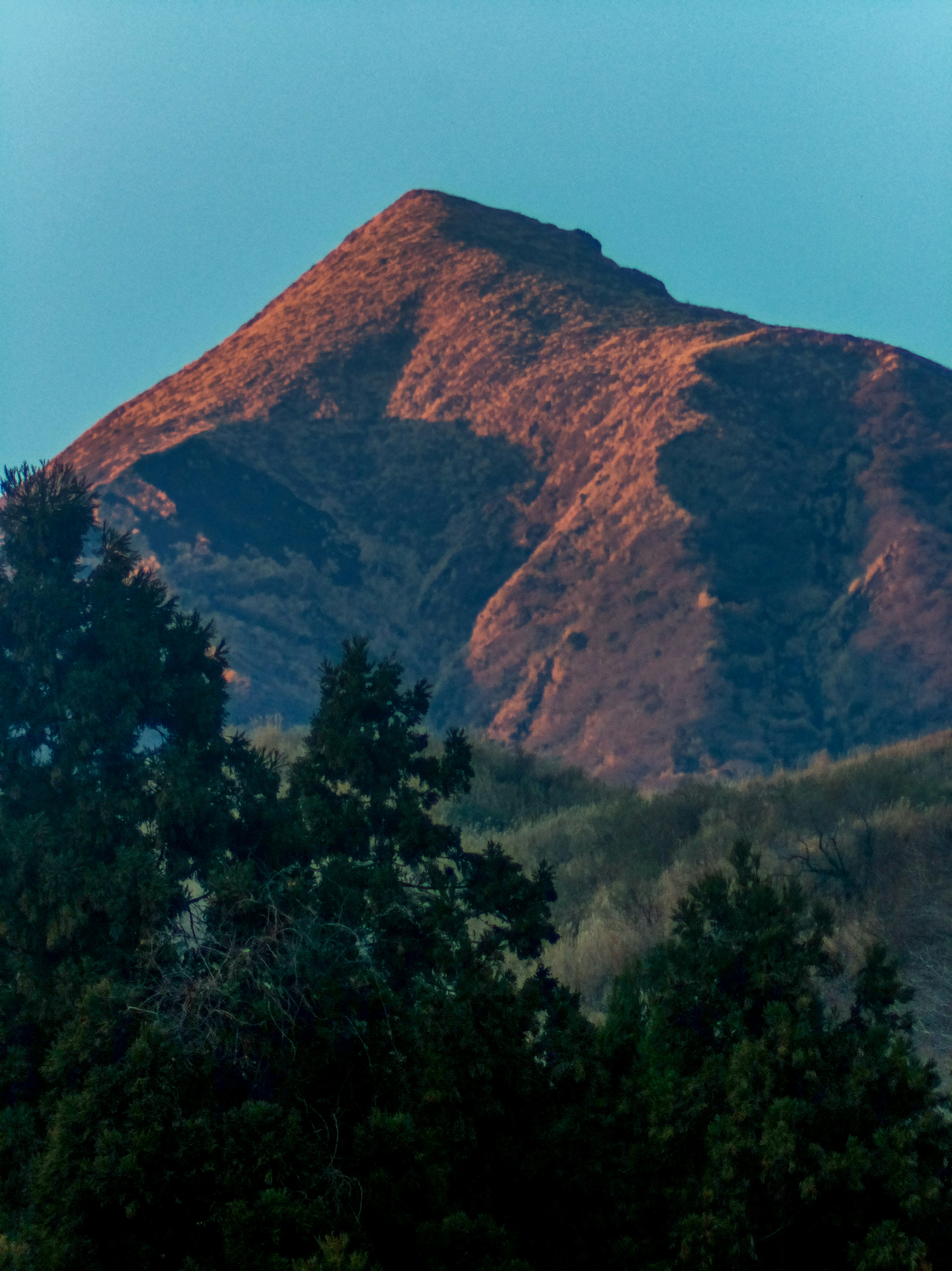 A mountain peak illuminated by the morning sun in a serene landscape