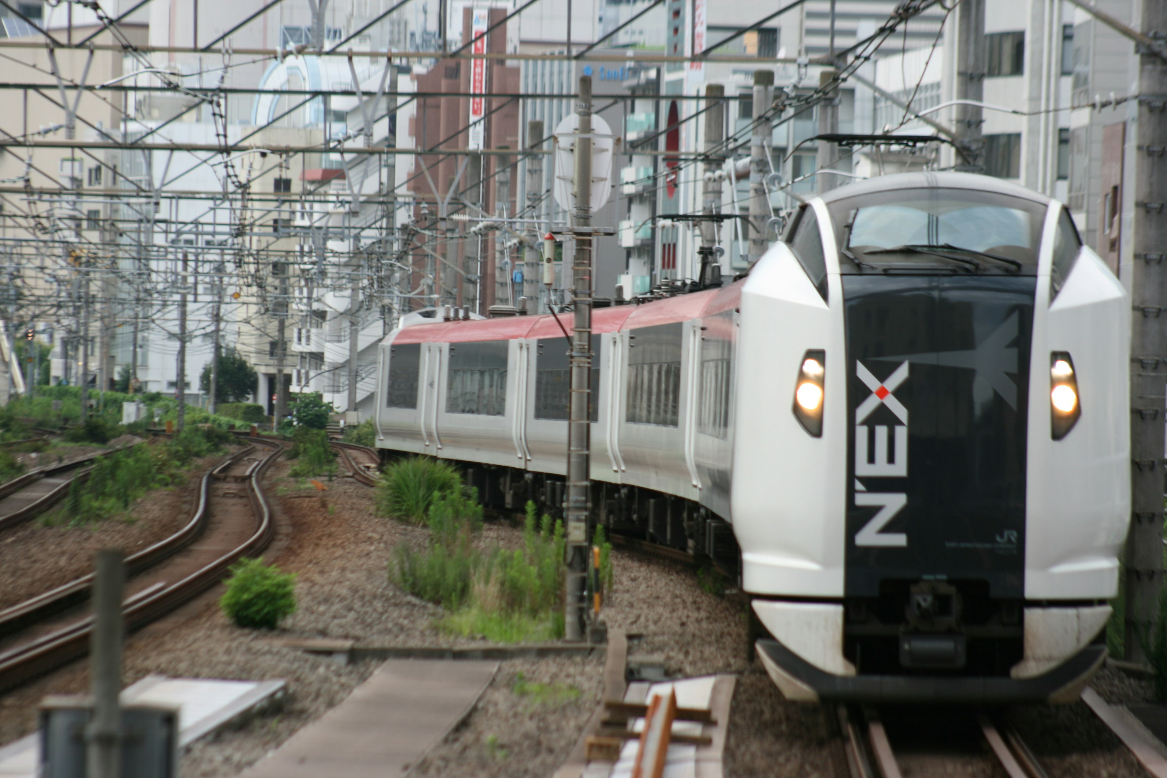 Ein Shinkansen-Zug, der durch eine städtische Umgebung fährt