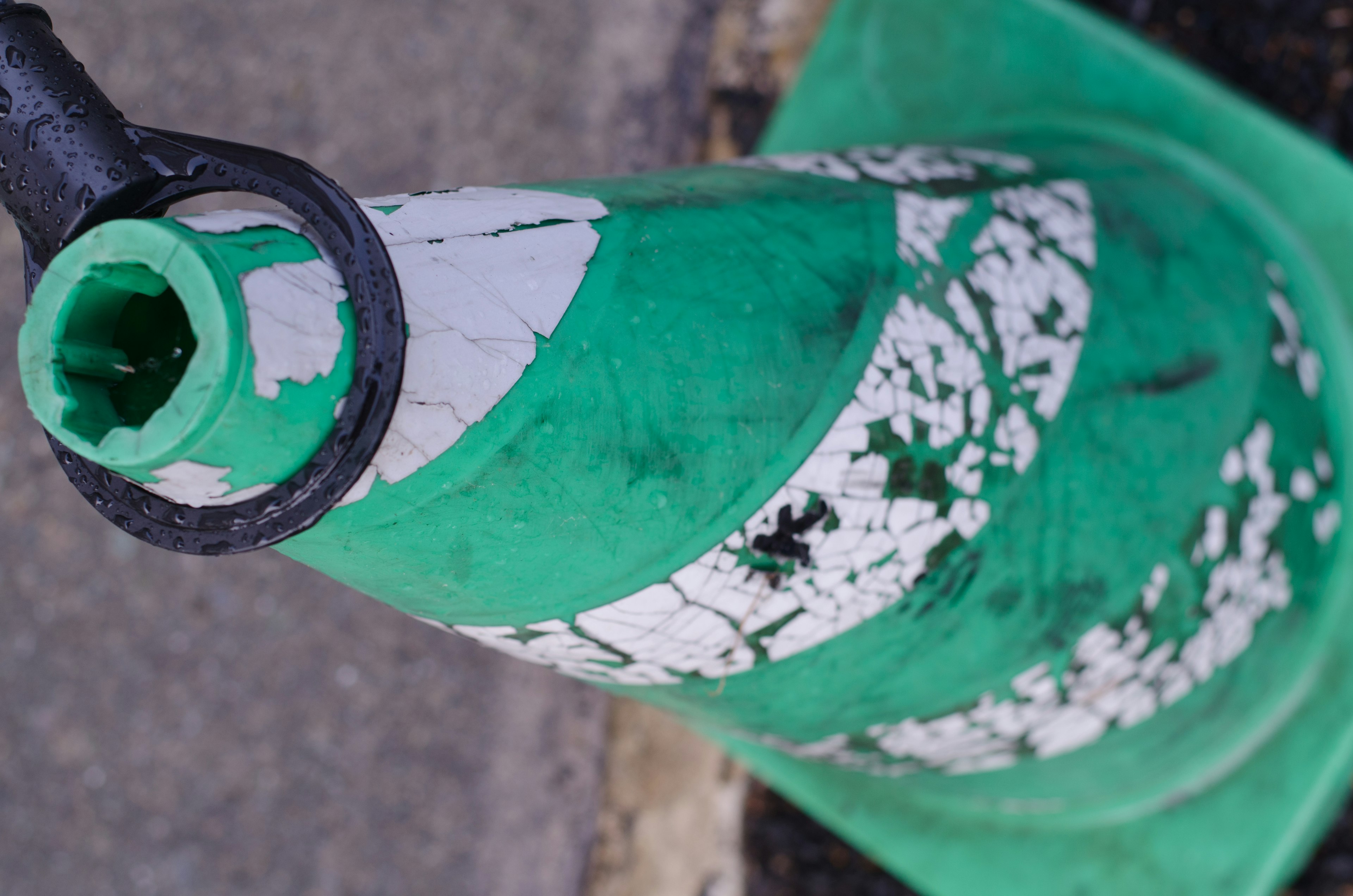 Close-up image of a green and white striped traffic cone