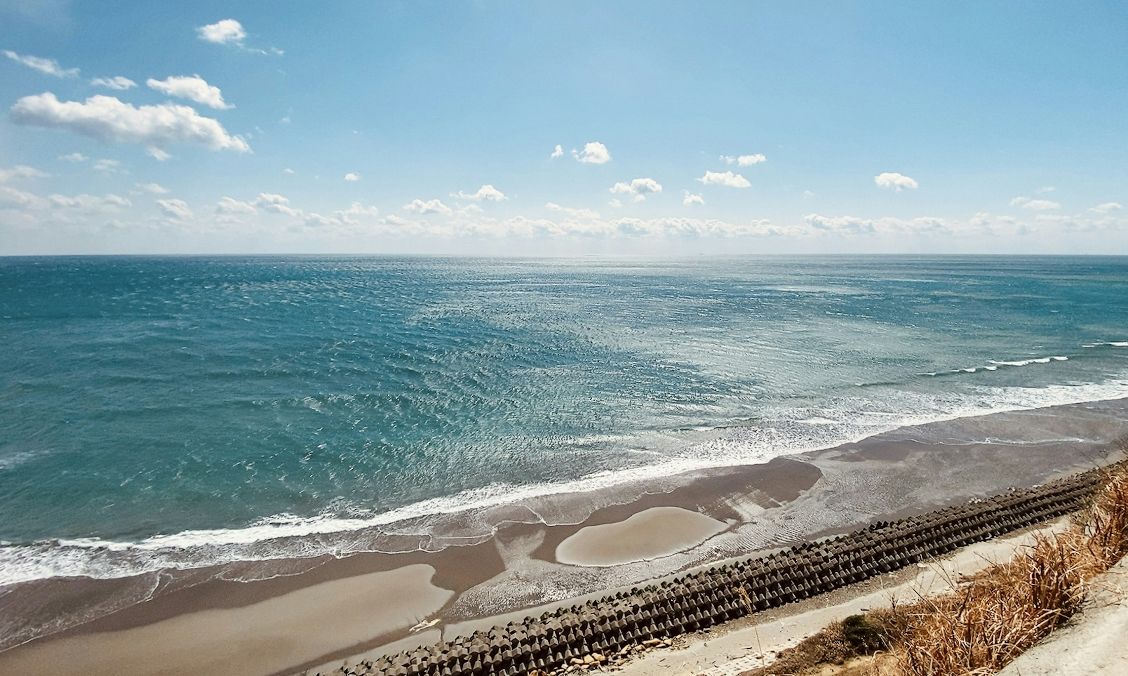 Panoramablick auf den blauen Ozean und den Sandstrand unter klarem Himmel