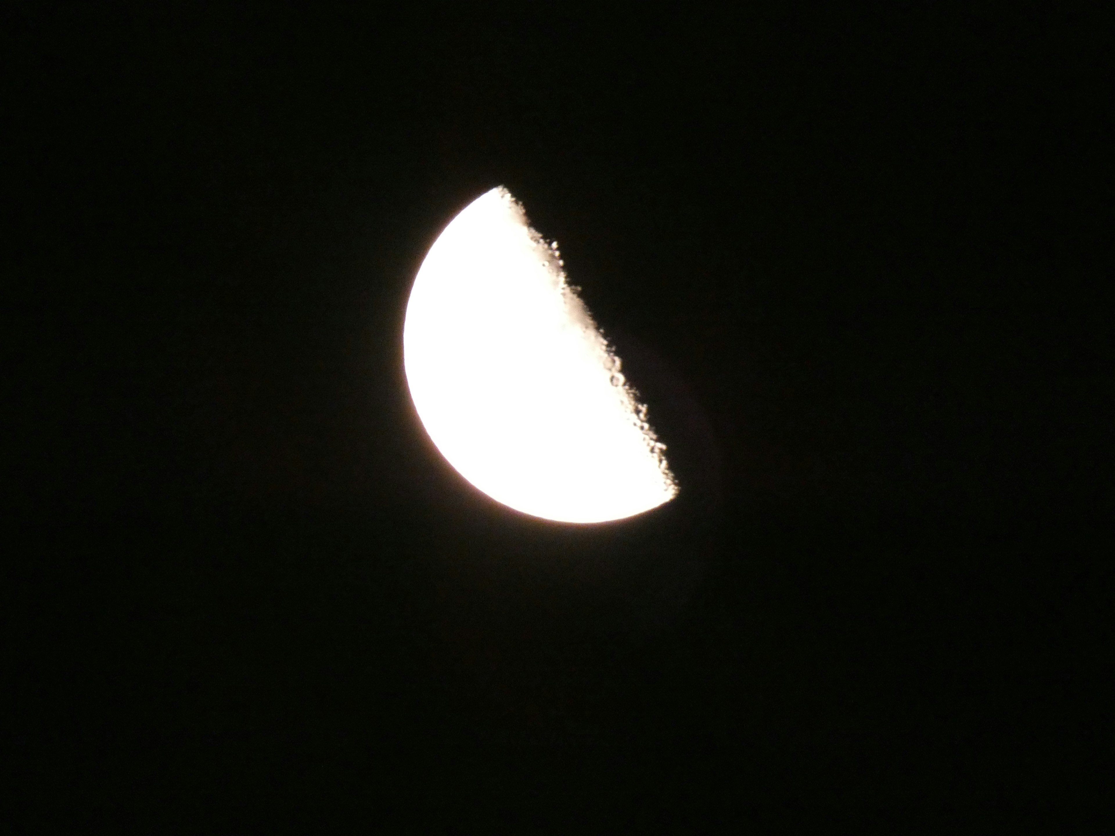 Half of the moon illuminated in the night sky