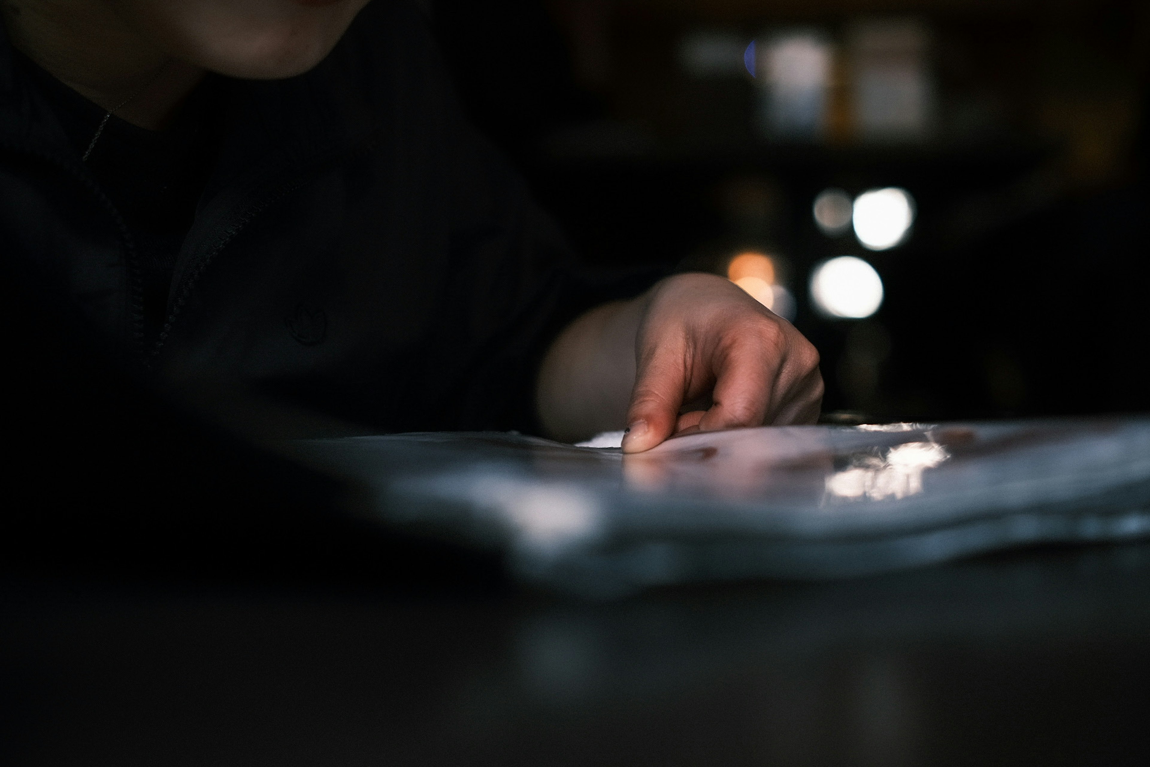 Una mano che punta qualcosa in un ambiente poco illuminato