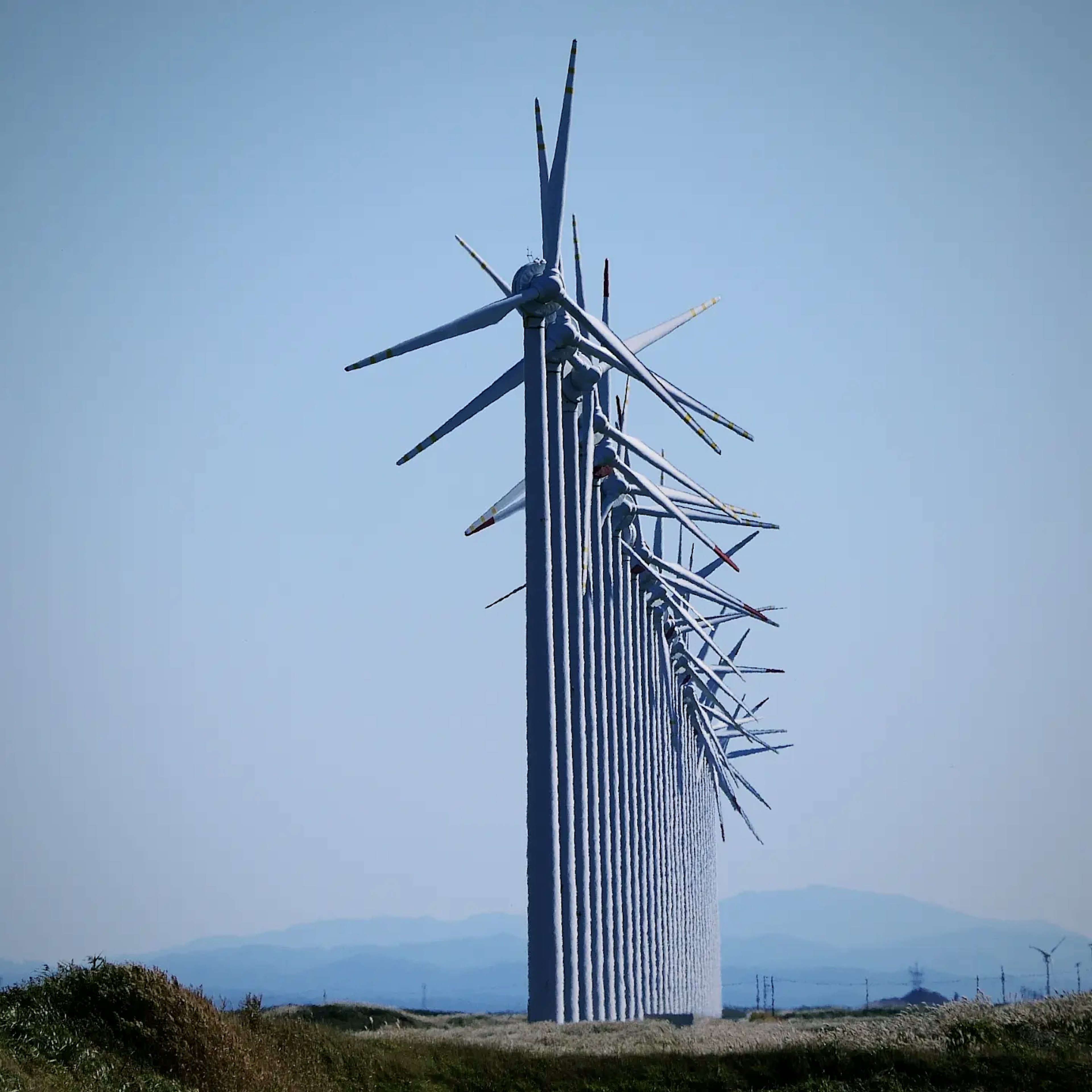 Row of wind turbines against a clear blue sky