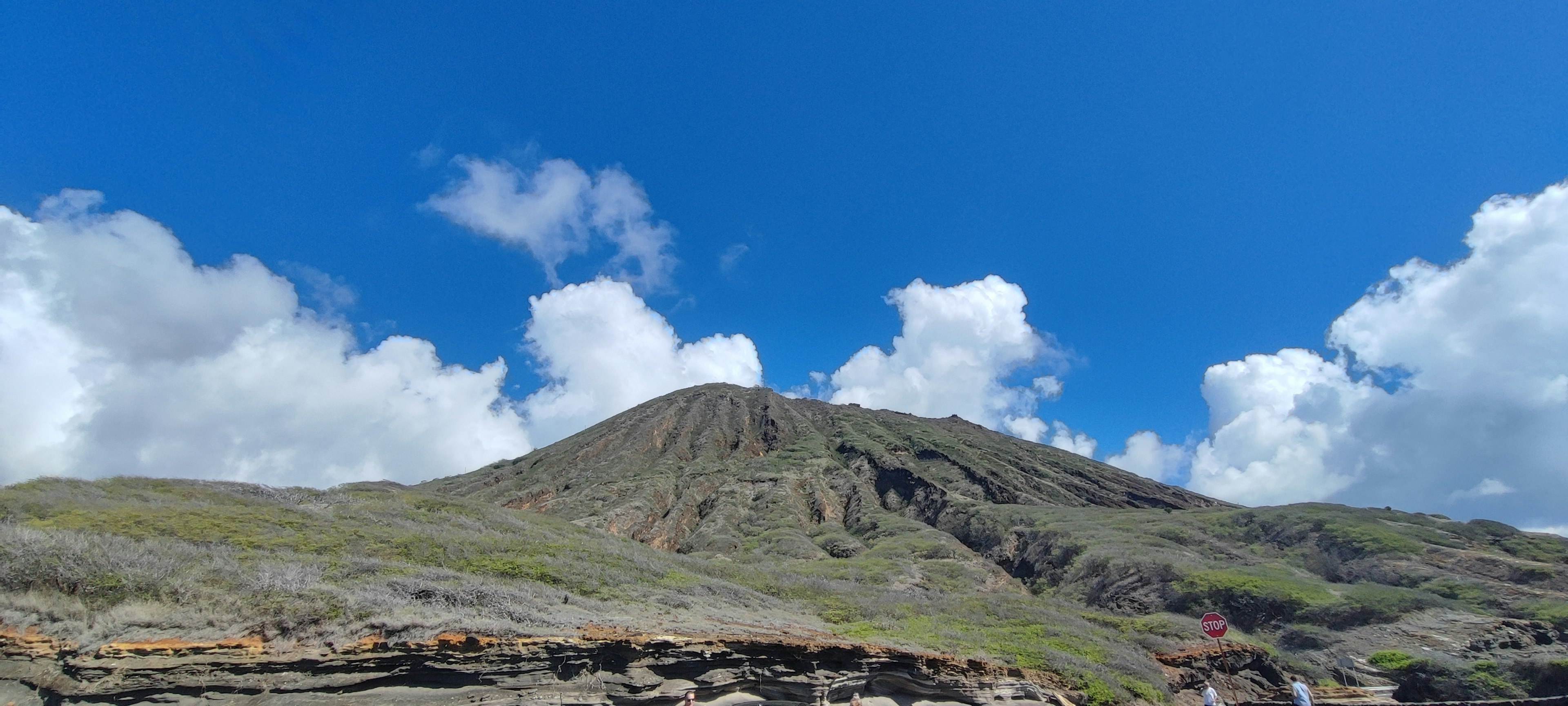 Paisaje montañoso rodeado de cielo azul y nubes blancas