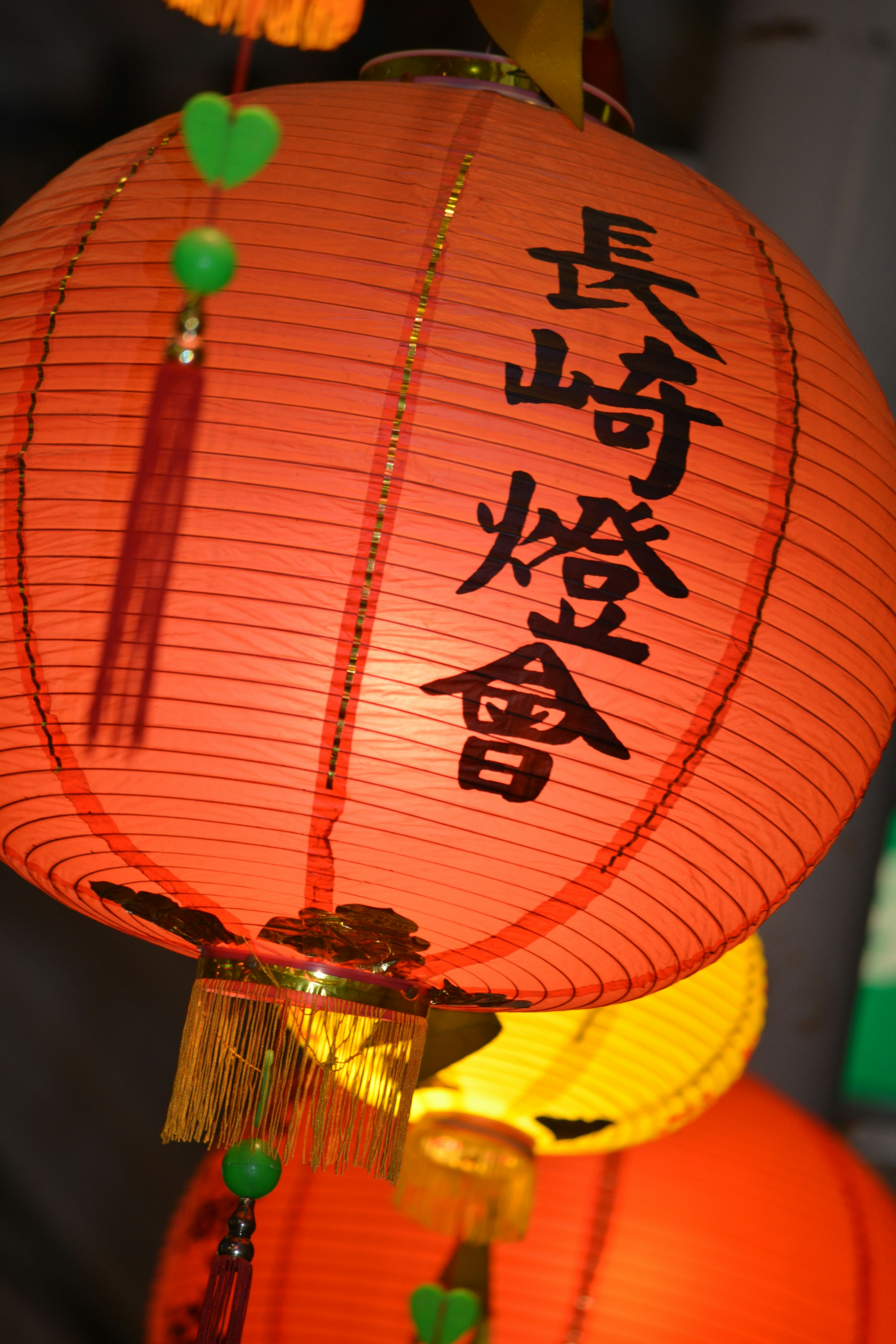 Orange lantern featuring Chinese characters Nagasaki Lantern Festival intricate decorations and vibrant design