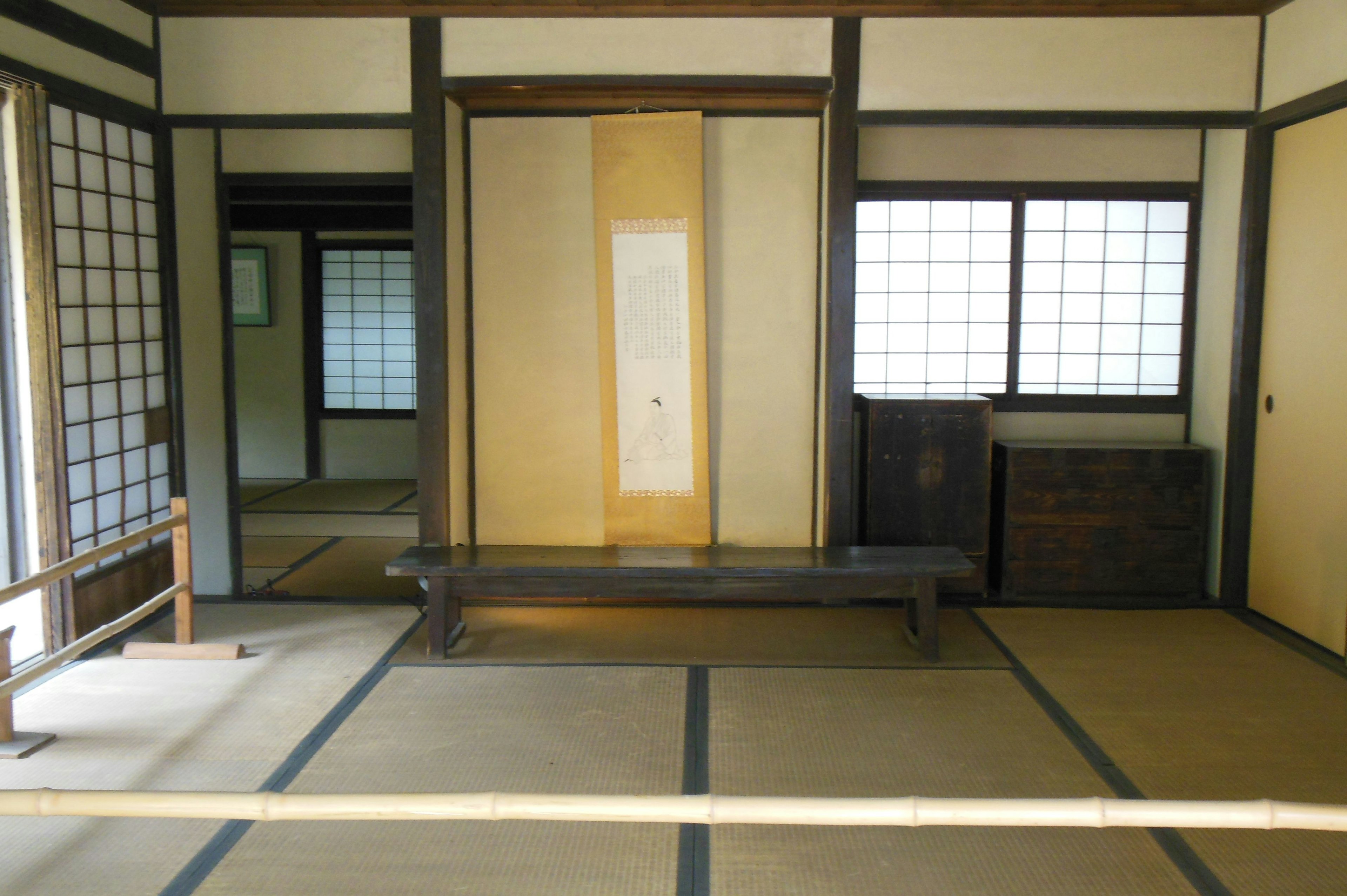 Interior of a traditional Japanese room featuring tatami mats wooden bench and bright windows